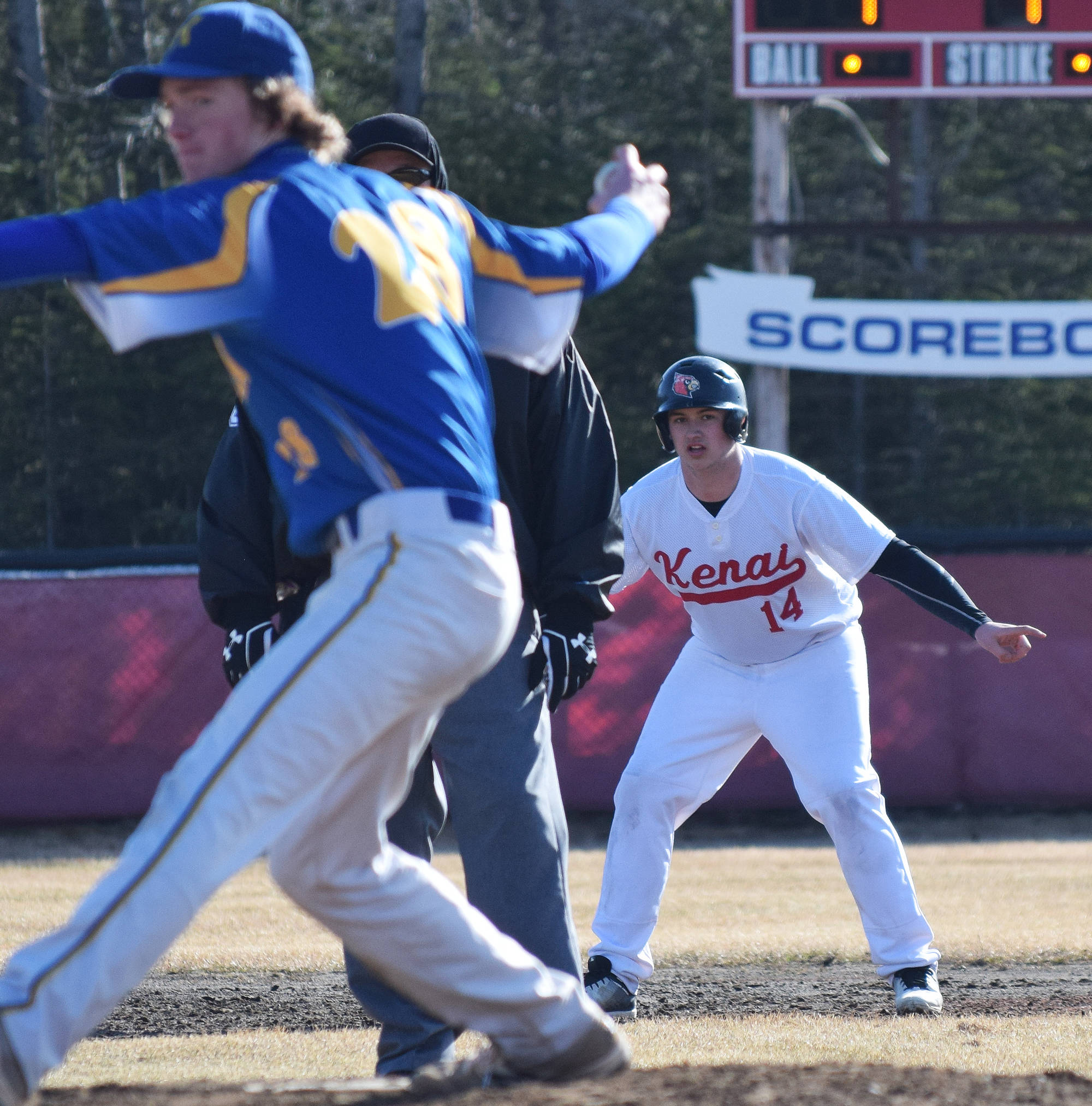 Kenai’s Andrew Carver (14) keeps an eye on Kodiak pitcher Nevin Lee after hitting a fourth-inning double Friday at the Kenai Little League Fields. (Photo by Joey Klecka/Peninsula Clarion)