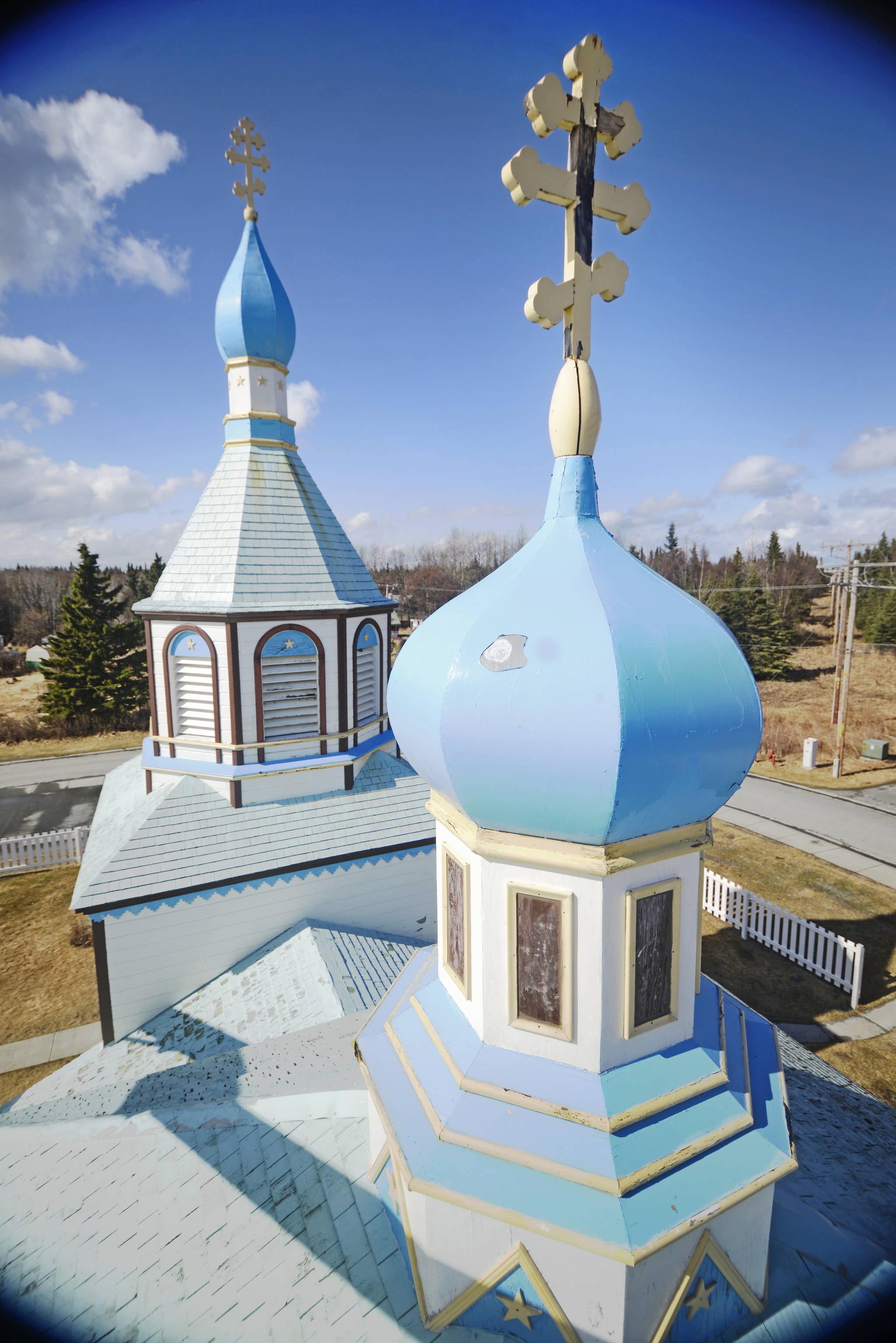 Shortly before its removal, an aged and weathered cross tops an onion dome of the Holy Assumption of the Virgin Mary Russian Orthodox Church on Friday, May 4 in Kenai. Replacing the church’s shingle roof, which is original to its construction in 1896, is the next and final major project of Holy Assumption’s decade-long effort to restore the historic building. (Ben Boettger/Peninsula Clarion)