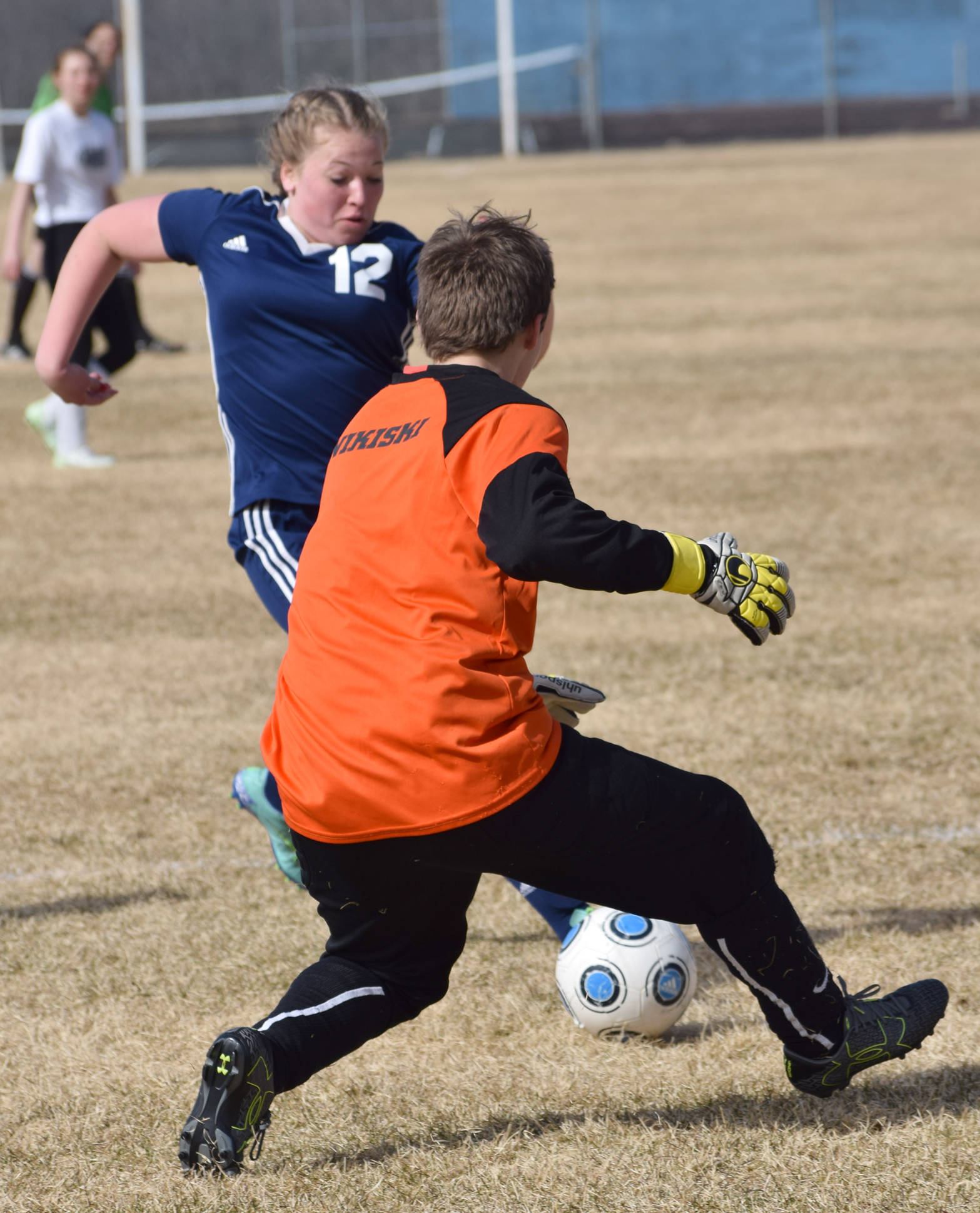 Soldotna’s Mykenna Foster and Nikiski goalie Abby Bystedt race to the ball Monday, May 7, 2018, at Nikiski High School. (Photo by jeff Helminiak/Peninsula Clarion)