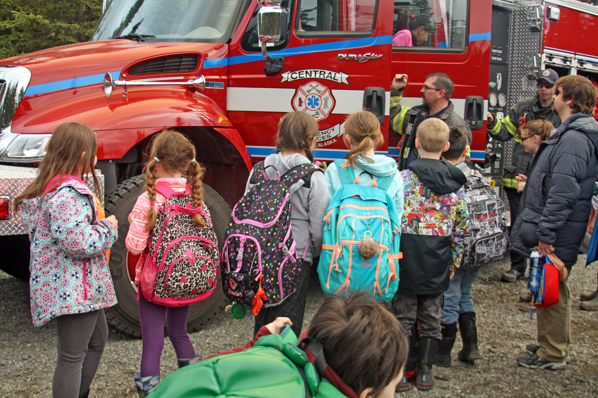 Students wait to get a look inside a fire engine at the 18th Annual Kenai Peninsula Salmon Celebration at Johnson Lake State Recreation Site in Kasilof. Central Emergency Services was one of the many community organizations that participated in the event, which featured hands-on activity booths and demonstration areas. (Photo by Erin Thompson/Peninsula Clarion)