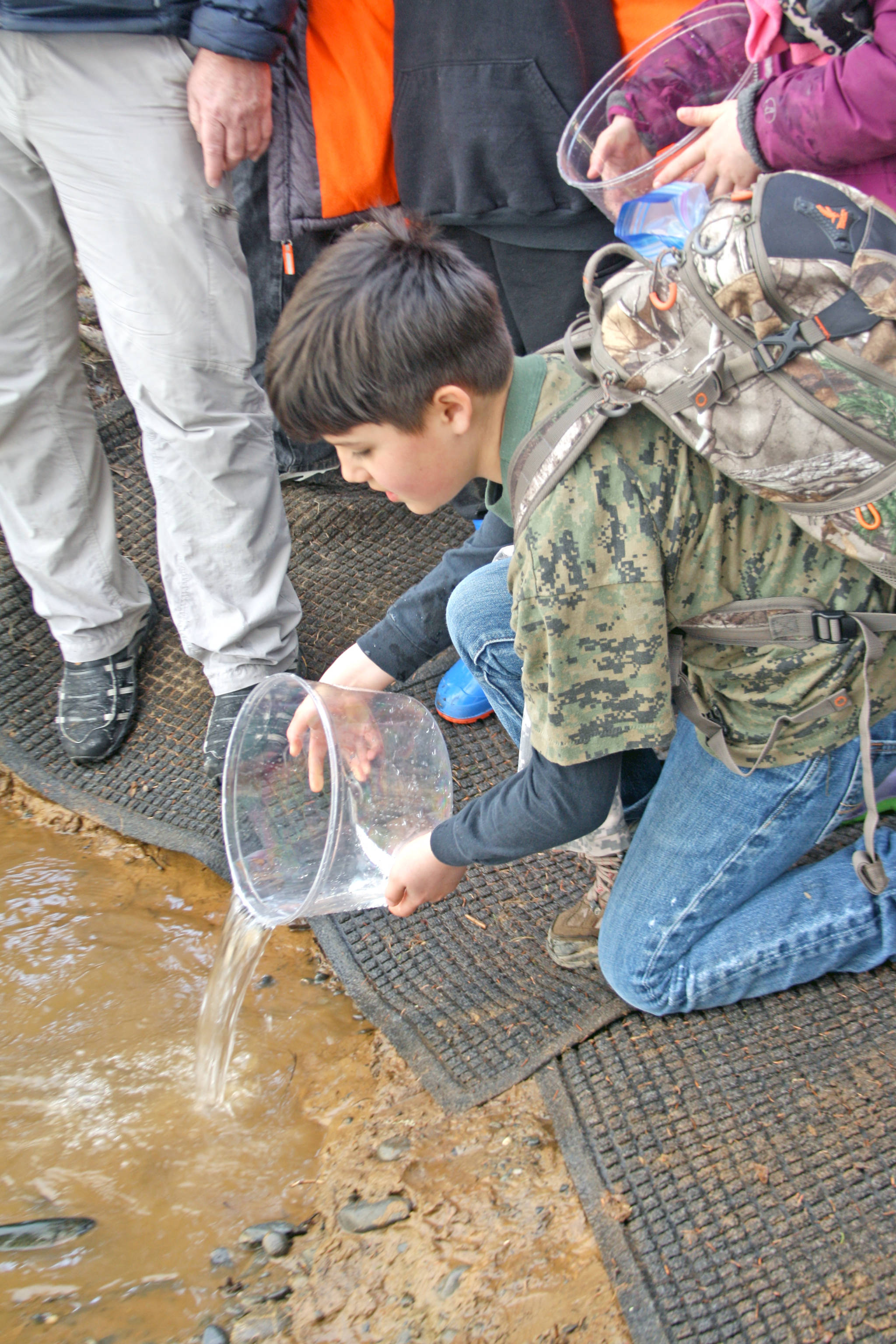 A student releases a rainbow trout into Johnson Lake during the 18th Annual Kenai Peninsula Salmon Celebration in Kasilof. Approximately 950 borough students released 5,000 fish into Johnson Lake as part of an Alaska Department of Fish and Game restocking effort. (Photo by Erin Thompson/Peninsula Clarion)