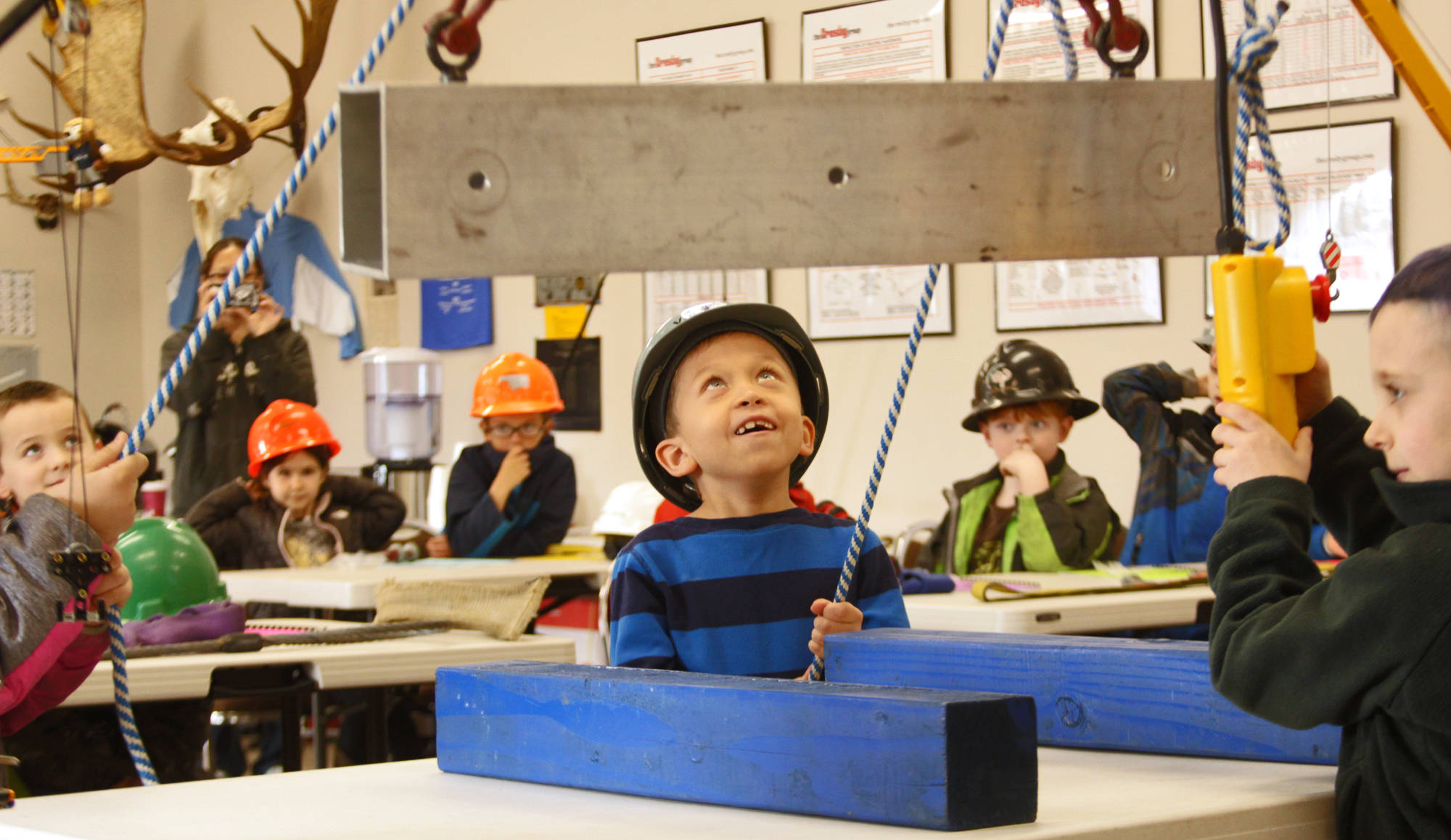 Aiden Gilliam steadies a beam being lifted by a shop crane during his class’s field trip to Alaska Crane Consultants on Monday, May 7, 2018 on Kalifornsky Beach road. (Ben Boettger/Peninsula Clarion)