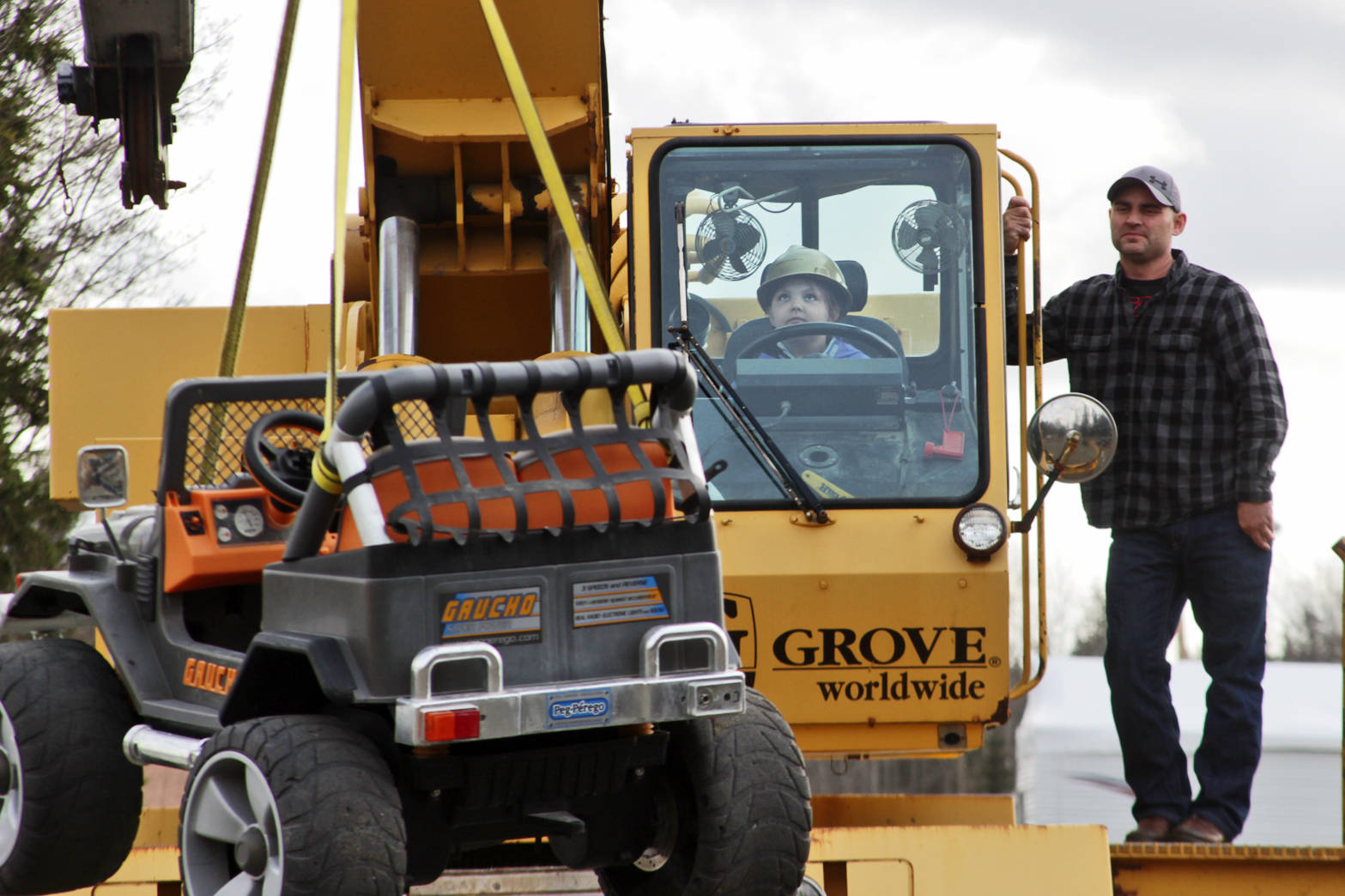 Madison Hibpshman (left) uses a crane to lift a toy electric jeep, watched by Mike Elmore, during her class’s field trip to Alaska Crane Consultants on Monday, May 7, 2018 on Kalifornsky Beach road. (Ben Boettger/Peninsula Clarion)