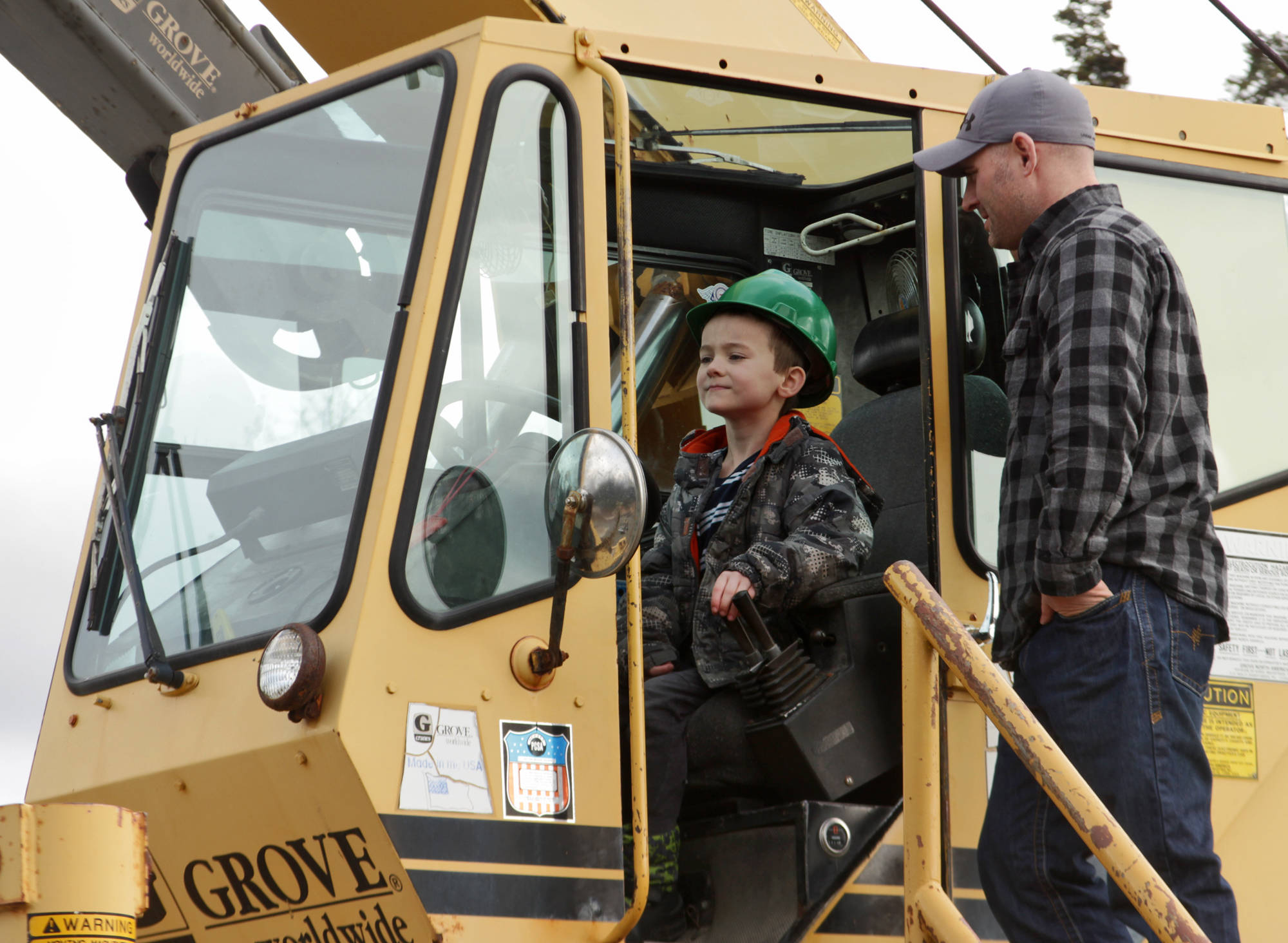 Kalifornsky Beach Elementary first-grader Nate Coon operates a crane, watched by Mike Elmore during his class’s field trip to Alaska Crane Consultants on Monday, May 7, 2018 on Kalifornsky Beach road. (Ben Boettger/Peninsula Clarion)