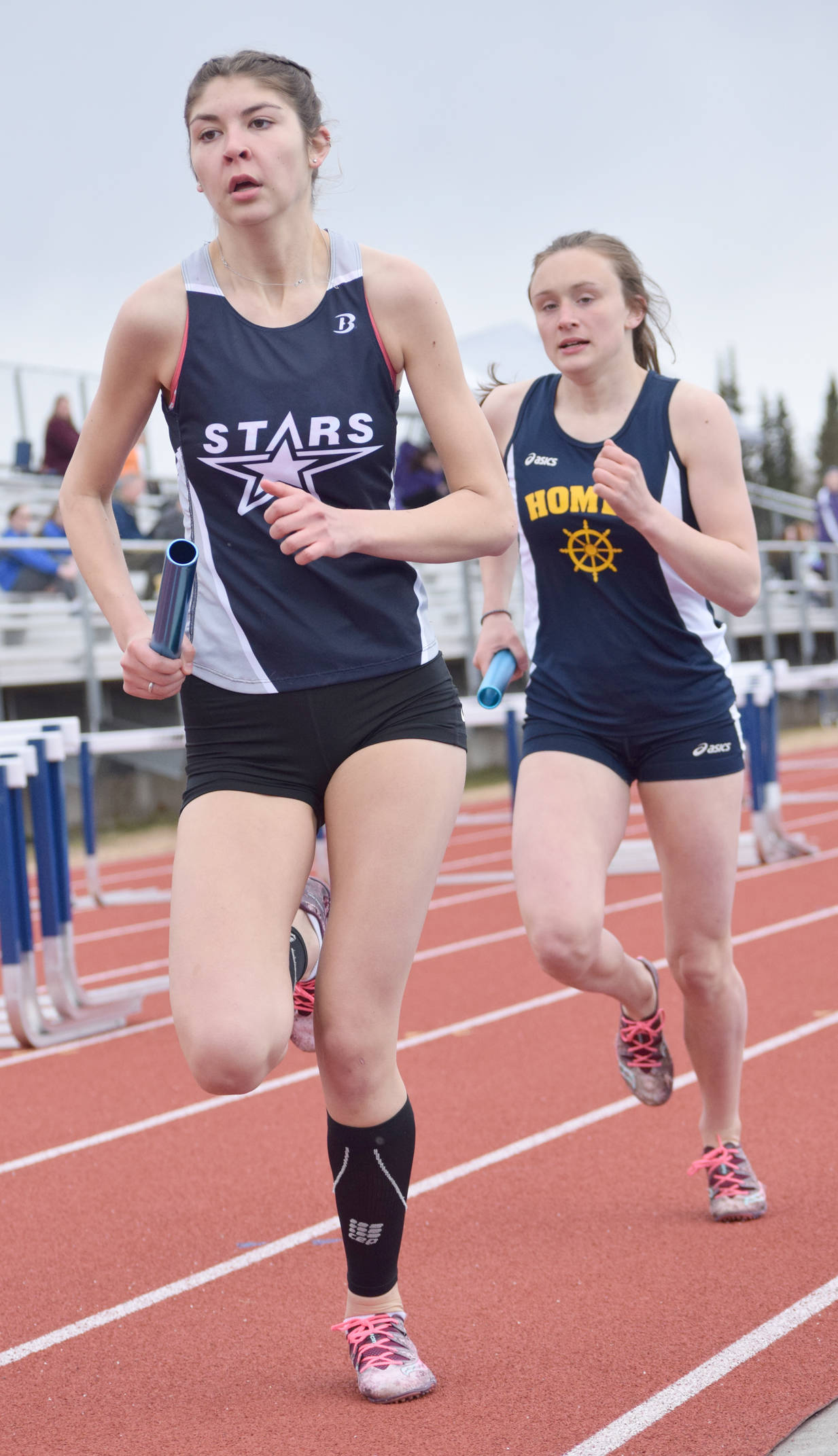 Soldotna’s Kellie Arthur tries to hold off Homer’s Autumn Daigle in the final leg of the 3,200-meter relay Saturday, May 12, 2018, at Soldotna High School. Daigle would pass Arthur for the victory. (Photo by Jeff Helminiak/Peninsula Clarion)