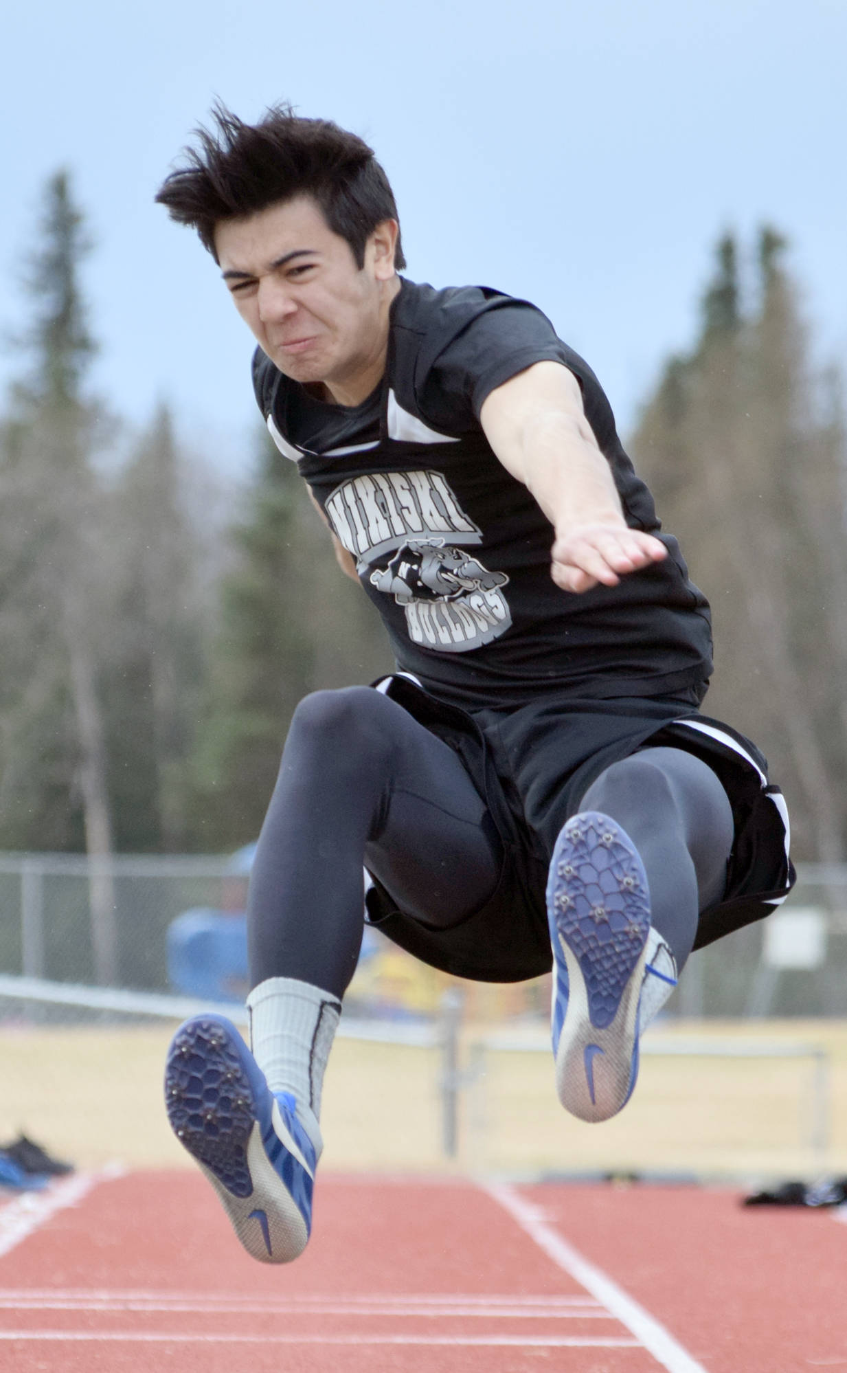 Nikiski’s Jack Sullenger competes in the long jump Saturday, May 12, 2018, at the Kenai Peninsula Borough track and field meet at Soldotna High School. (Photo by Jeff Helminiak/Peninsula Clarion)