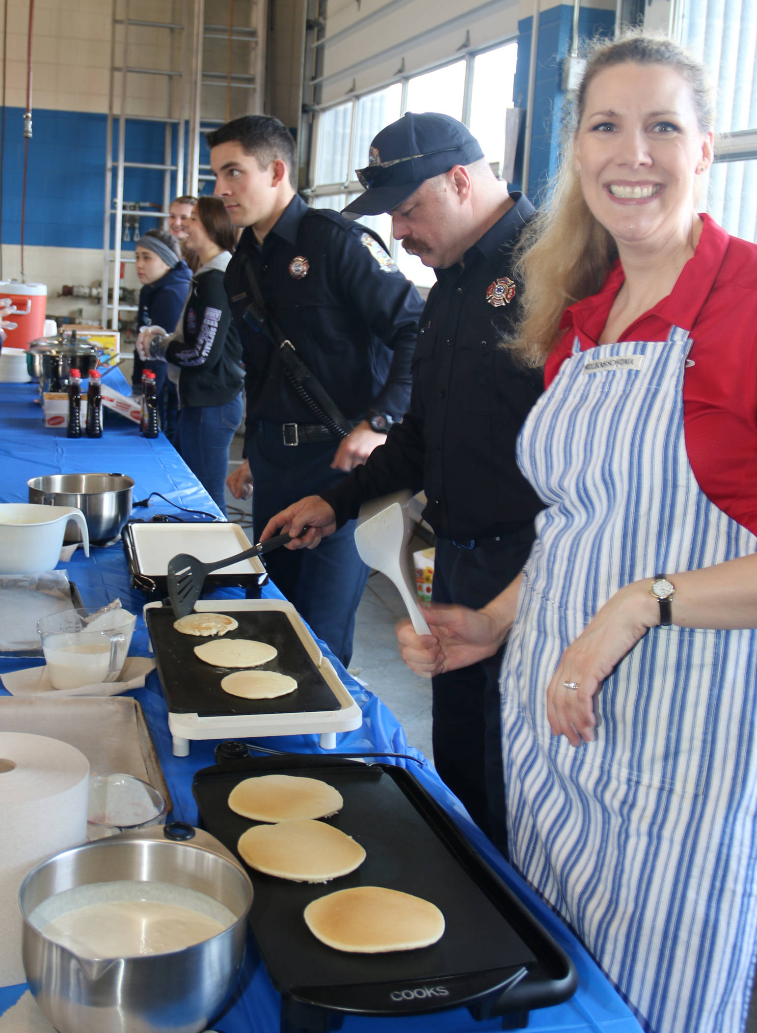 Claudia Browning flips the flap jacks during community dedication open house.