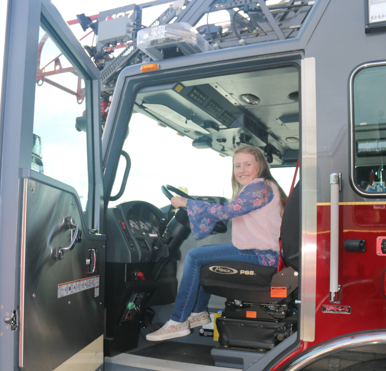 Ten-year-old Emerson Kapp sits in the new CES ladder truck at dedication open house.