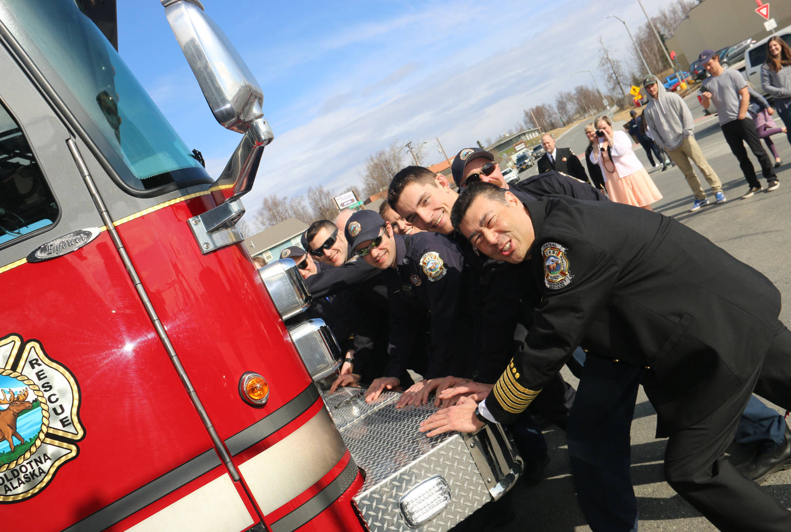 Chief Browning and first responders push a new ladder truck into its bay to officially dedicate it to service.