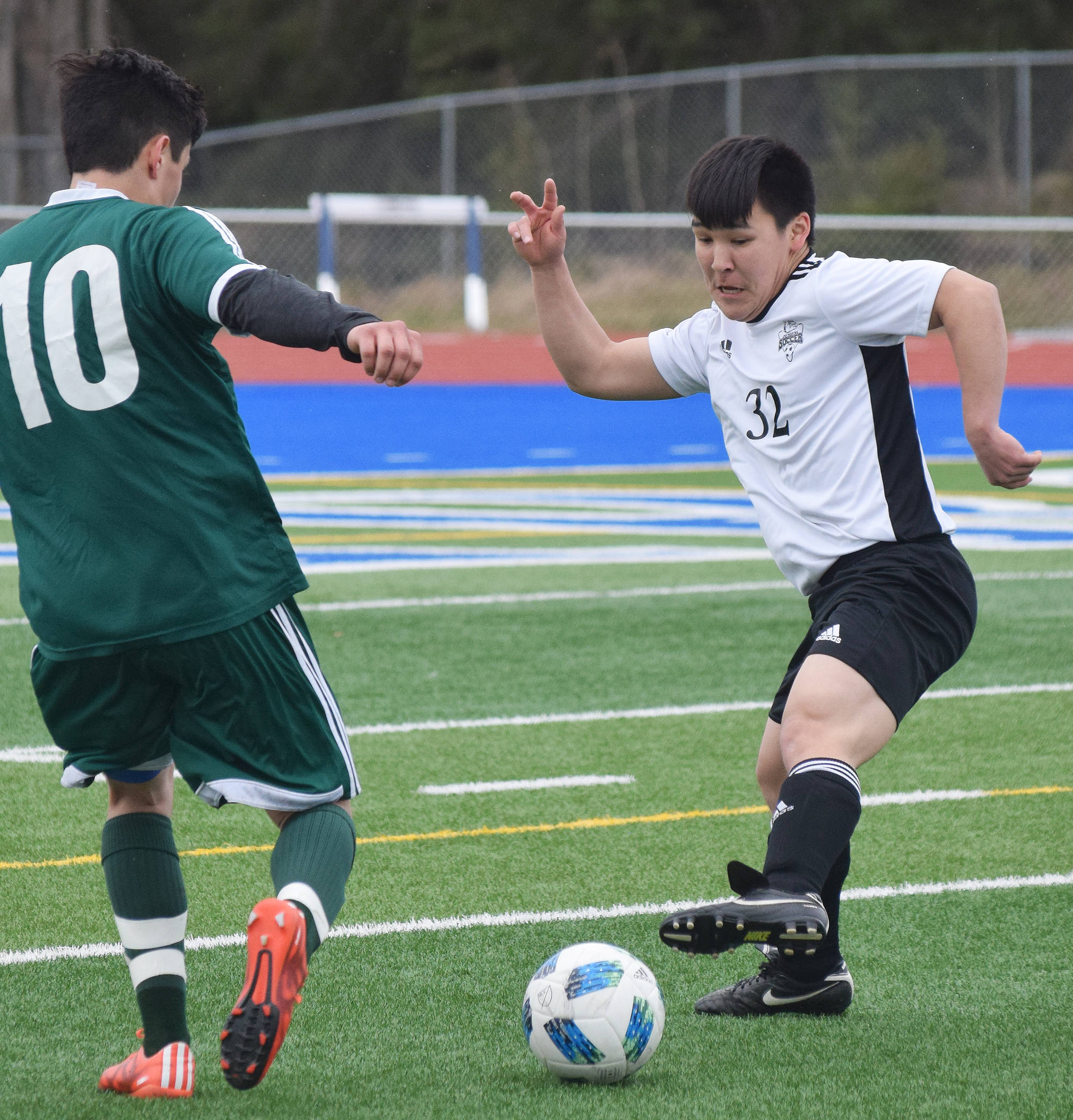 Nikiski’s George Napoka (32) tips the ball away from Seward’s Brandon Lynch Thursday at the Peninsula Conference tournament at Soldotna High School. (Photo by Joey Klecka/Peninsula Clarion)