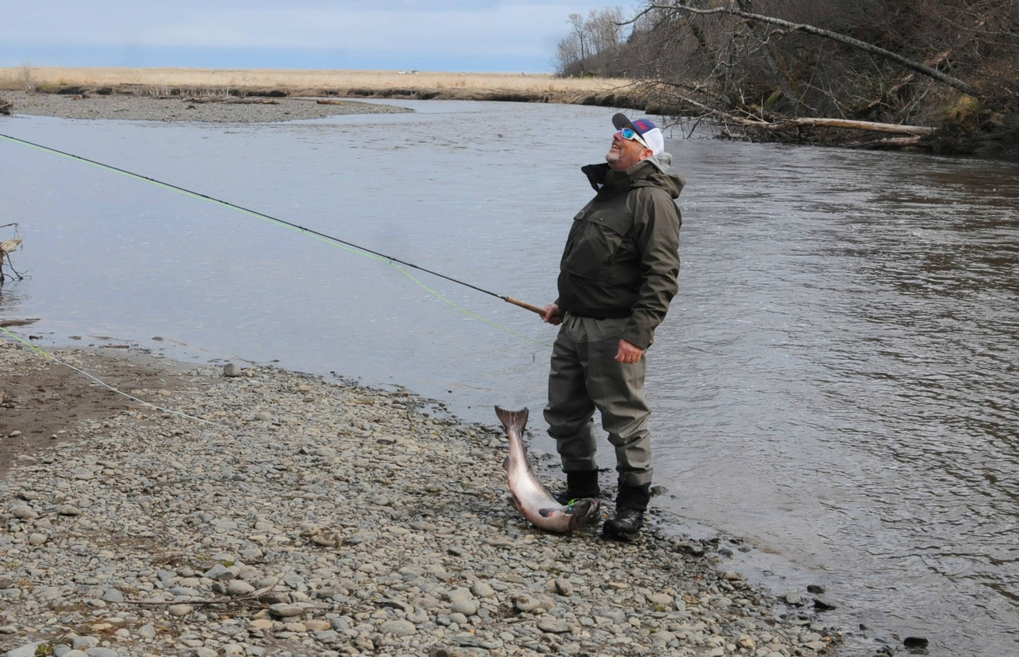 Terry Umatum of Anchorage takes a deep breath after landing his Anchor River king salmon on Saturday, May 19, 2018 in Anchor Point, Alaska. The Anchor River opening May 19 was the first chance for freshwater anglers on the Kenai Peninsula to catch king salmon. Saturday proved a slow morning for fishing — Umatum said he waited about 5 hours to catch his king — though it’s still early in the season. The Alaska Department of Fish and Game’s weir on the Anchor River has counted precisely zero kings so far this year, as of Saturday, though the weir is positioned several miles upriver from the mouth. (Photo by Elizabeth Earl/Peninsula Clarion)