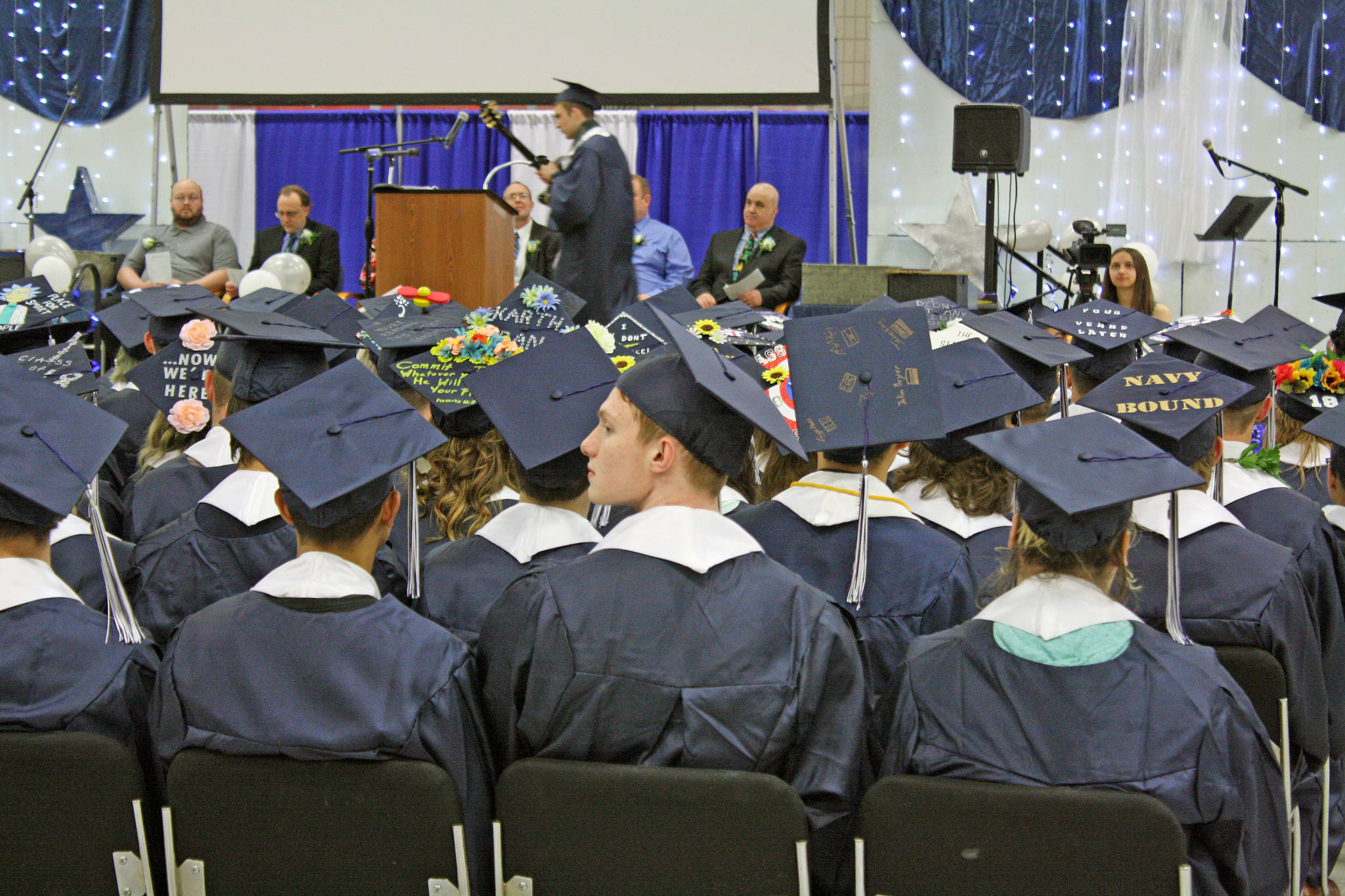A graduate listens to a musical performance during the Soldotna High School commencement at the Soldotna Sports Complex on Tuesday. (Photo by Erin Thompson/Peninsula Clarion)