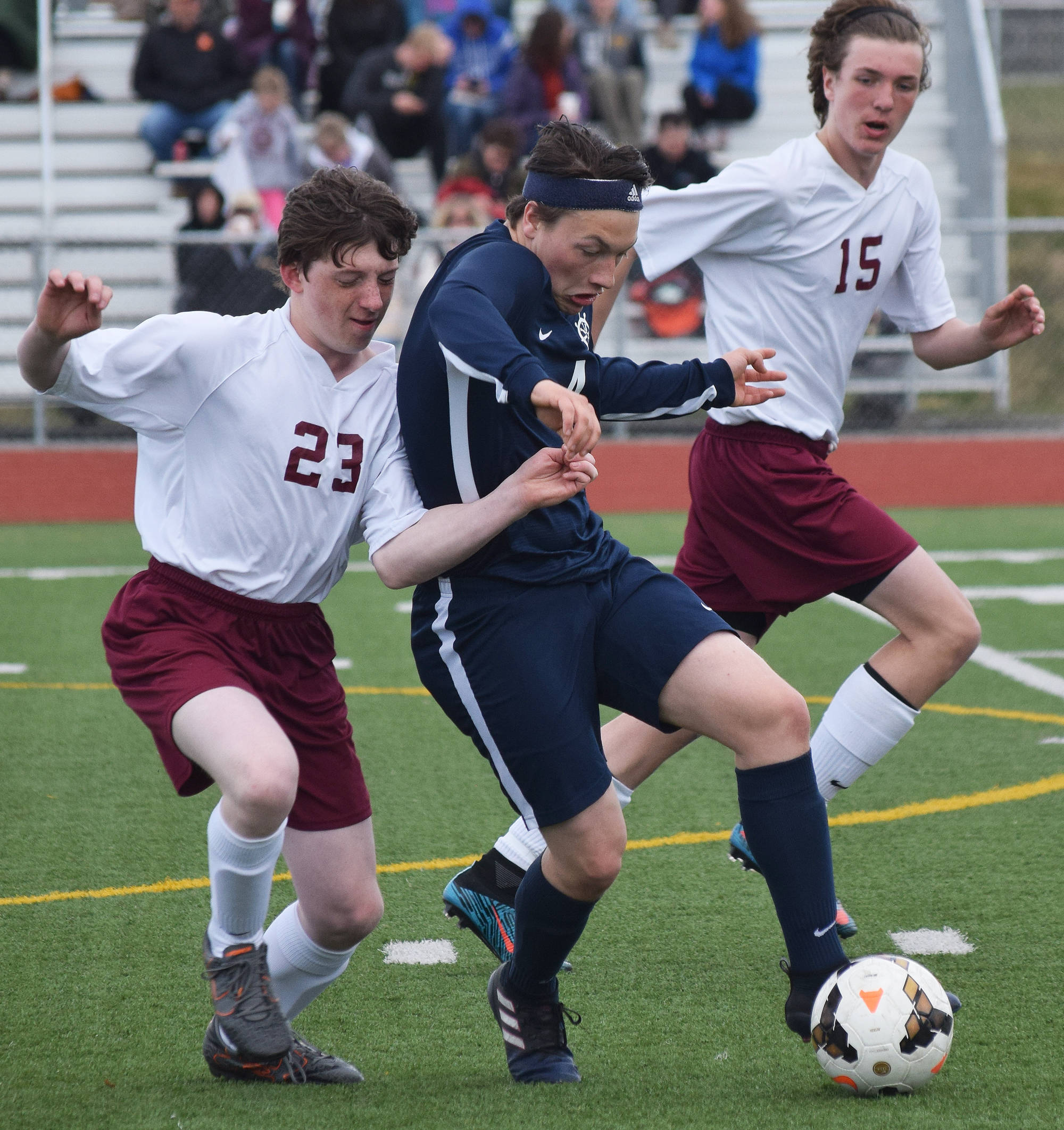 Homer midfielder Timothy Blakely (center) battles for the ball against Grace’s Dylan Harris (23) and Luke Schaezlien Thursday in Division II soccer tournament play at Eagle River High School. (Photo by Joey Klecka/Peninsula Clarion)
