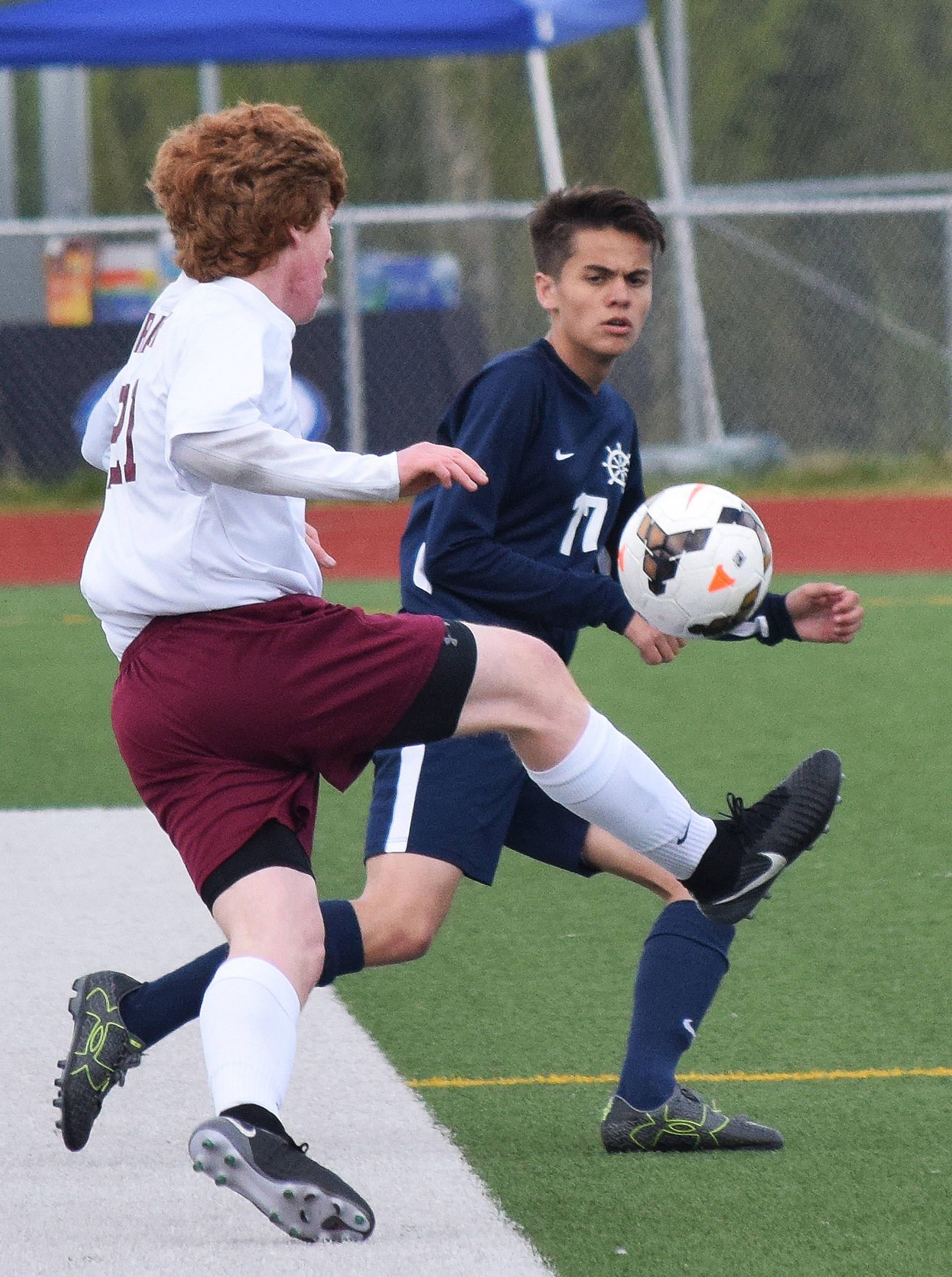 Homer’s Isaiah Nevak attempts to thwart the plan of Grace forward Paul Kopp Thursday in Division II soccer tournament play at Eagle River High School. (Photo by Joey Klecka/Peninsula Clarion)
