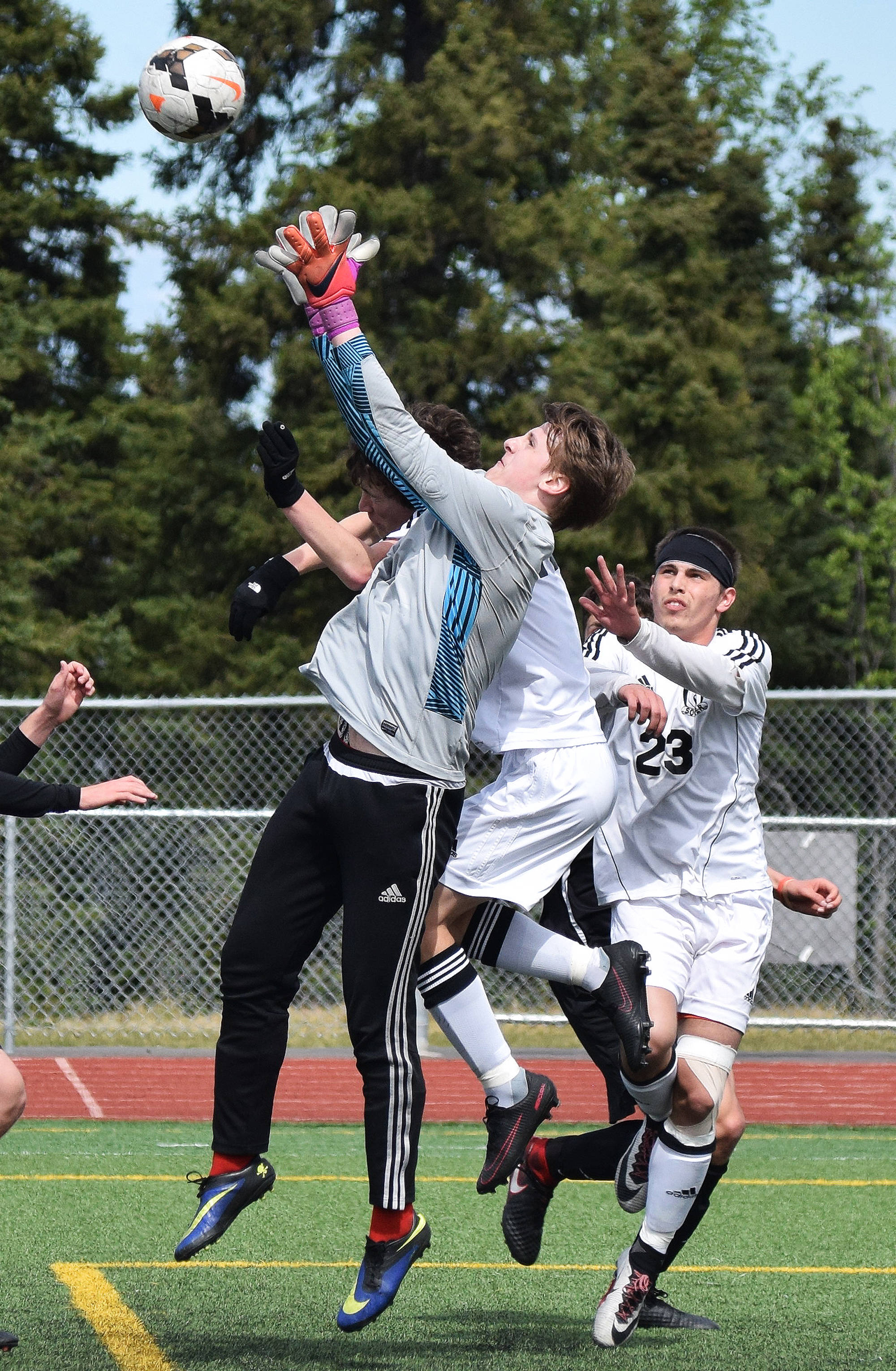Juneau goalkeeper Mitchell McDonald grabs a shot on goal from Kenai Central with Zack Tuttle (23) looking on, in the Division II state soccer championship final Saturday afternoon at Service High School. (Photo by Joey Klecka/Peninsula Clarion)