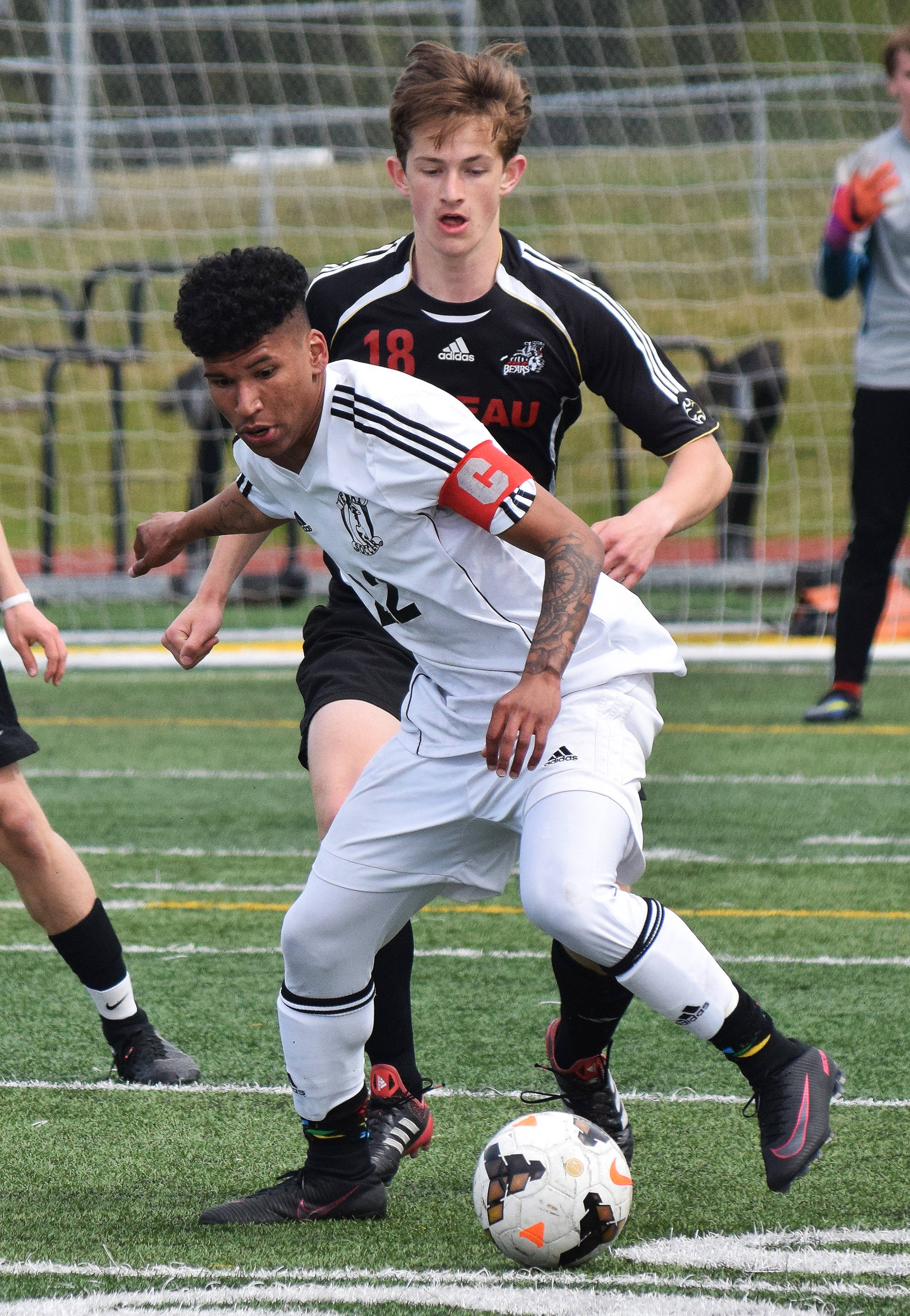 Kenai’s Kevin Ramos blocks out Juneau’s Clem Taylor-Roth from the ball in the Division II state soccer championship final Saturday afternoon at Service High School. (Photo by Joey Klecka/Peninsula Clarion)