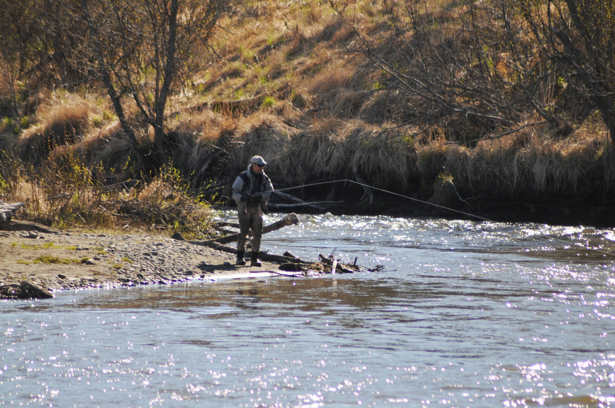 An angler tosses a line in at Deep Creek on Sunday, May 28, 2018 in Ninilchik, Alaska. Despite the perfect weather and holiday weekend, few anglers dotted the banks of the Ninlichik River and Deep Creek on Sunday, in part because the number of salmon in the rivers so far is still fairly paltry. The Alaska Department of Fish and Game classified the fishing over Memorial Day weekend as poor, in part because the water temperatures are still chilly for this time of year. (Photo by Elizabeth Earl/Peninsula Clarion)