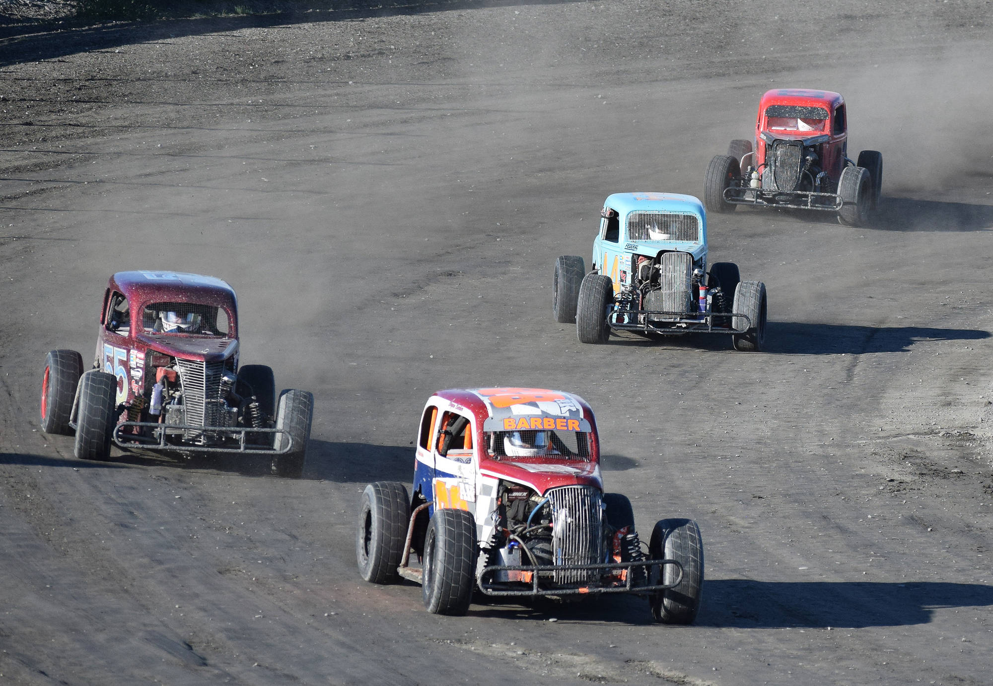 Bryan Barber leads a pack of Legend cars, including David Kusmider (second), Ty Torkelson (third) and Robert Spokes, Saturday night at Twin City Raceway in Kenai. (Photo by Joey Klecka/Peninsula Clarion)