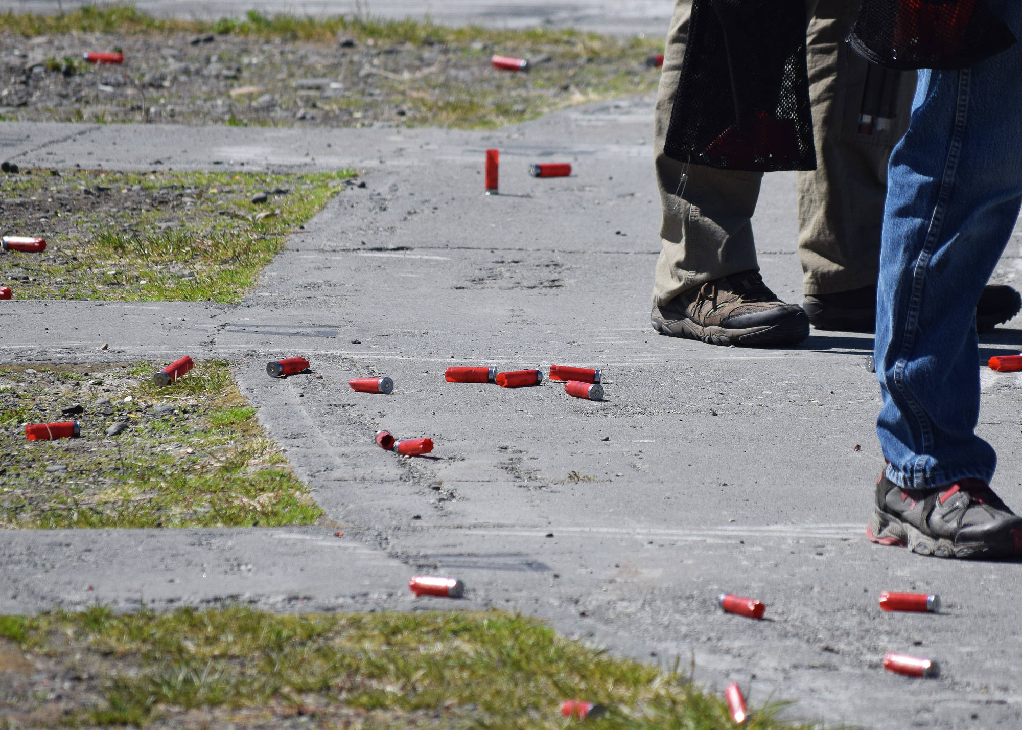 Empty cartridges litter the ground behind a row of shooters June 2 at a scholastic clay shooting event at the Snowshoe Gun Club in Kenai. (Photo by Joey Klecka/Peninsula Clarion)