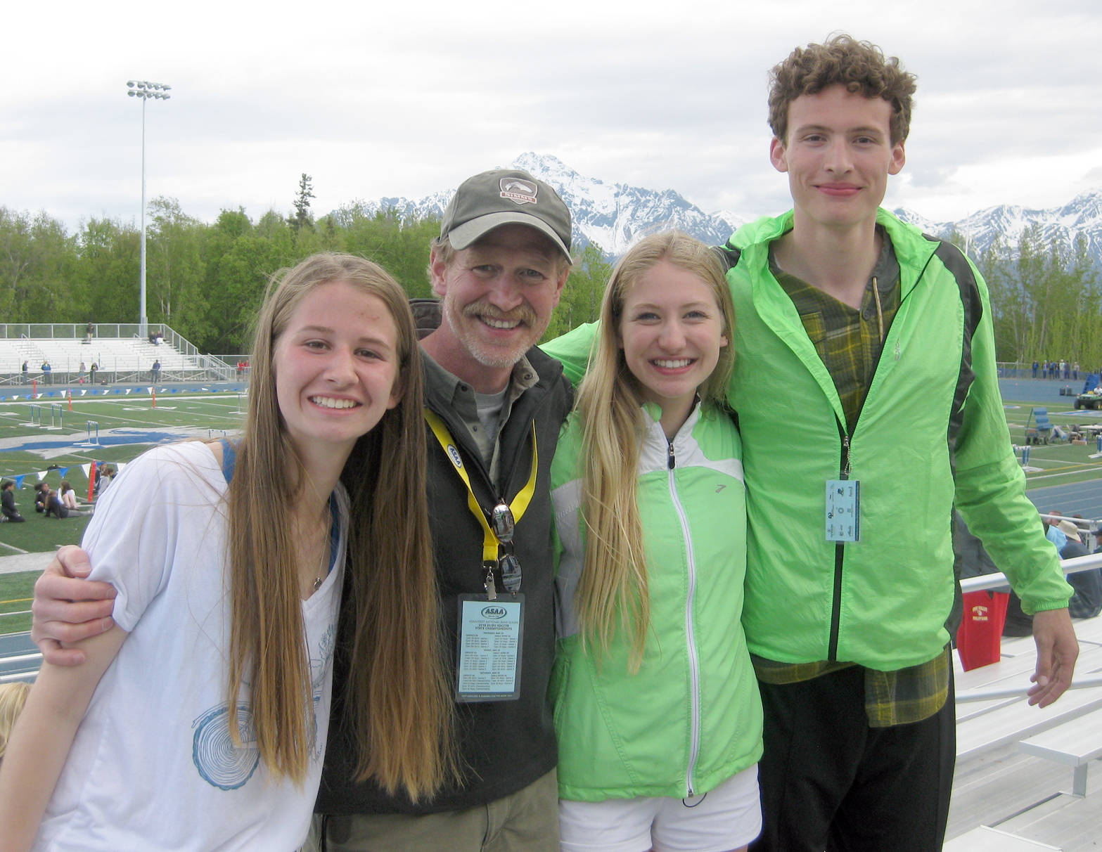 Seward’s Dan Marshall, retiring as cross-country and track coach focusing on distance events, poses with his last three seniors — Emma Moore, Ruby Lindquist and Zen Petrosius — at the state track and field meet at Palmer High School on May 25, 2018. (Photo provided by Jennifer Swander)