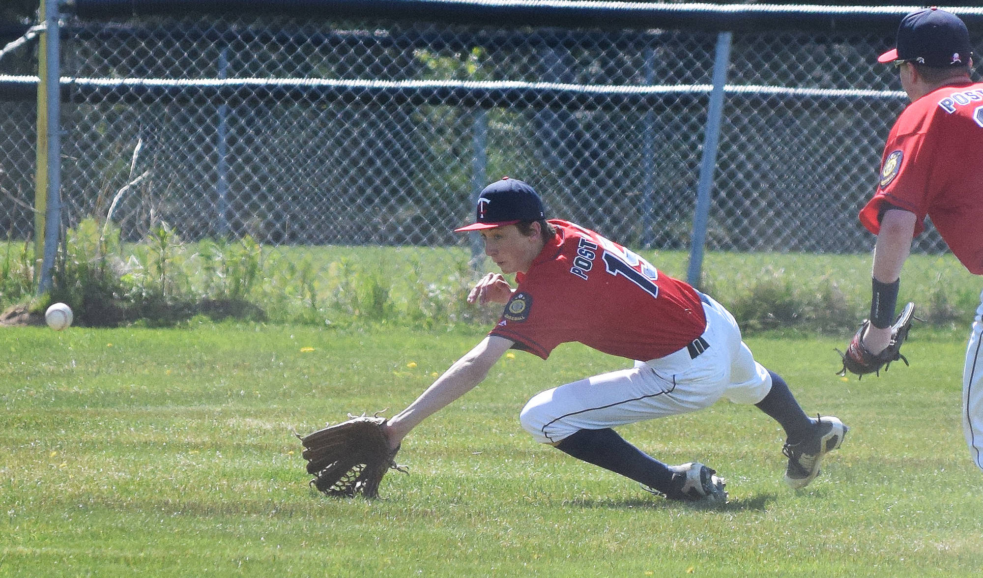 Twins left-fielder Trapper Thompson dives to cover up a line drive hit by a Bartlett batter Thursday afternoon at the Kenai Little League fields. (Photo by Joey Klecka/Peninsula Clarion)