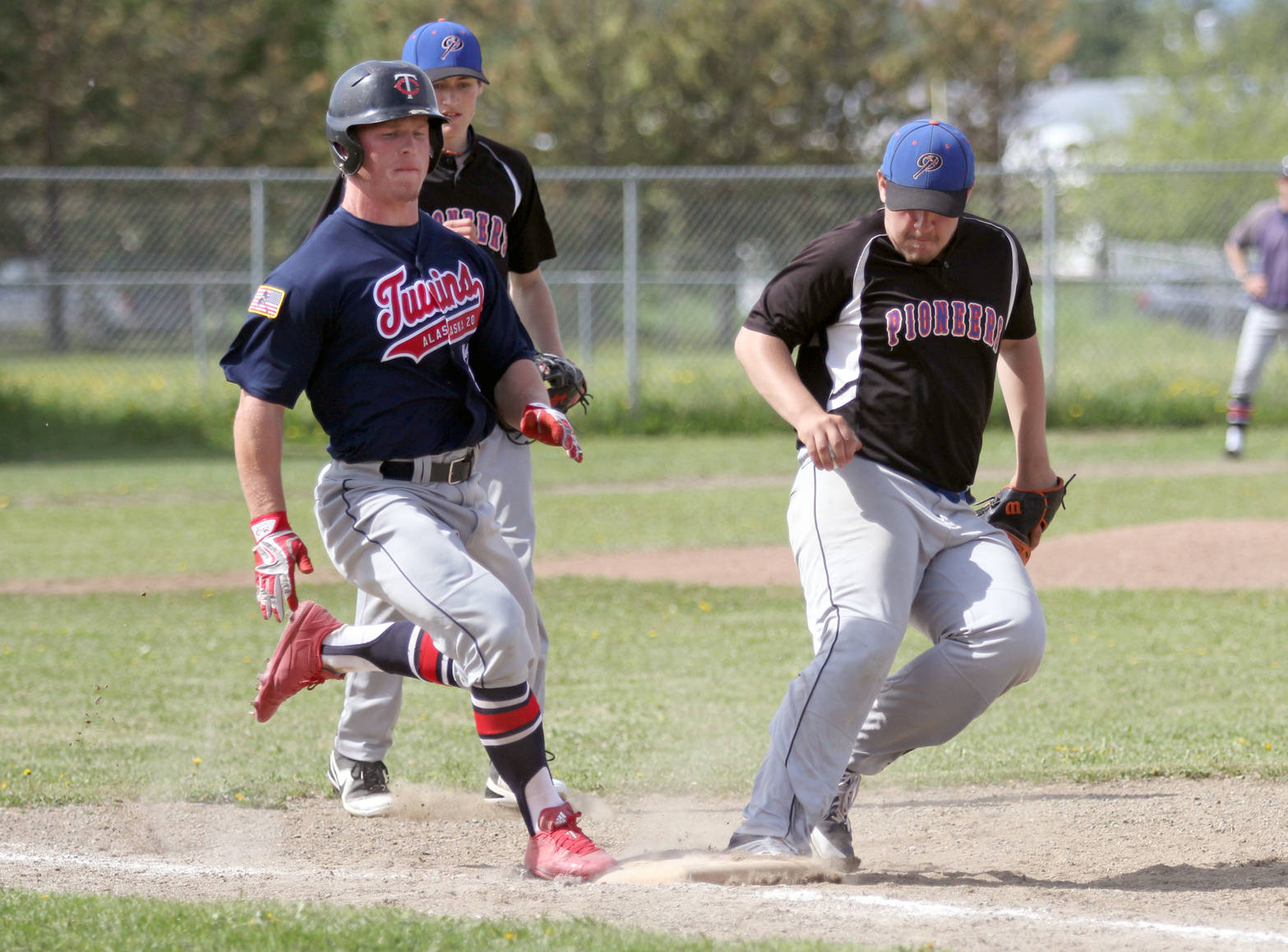 Kenai’s Paul Steffenson beats Palmer’s Zach Satterly to the bag during a play at first base in a 10-7 loss to the Pioneers on Sunday, June 10, 2018, in Palmer. (Photo by Jeremiah Bartz/Frontiersman)
