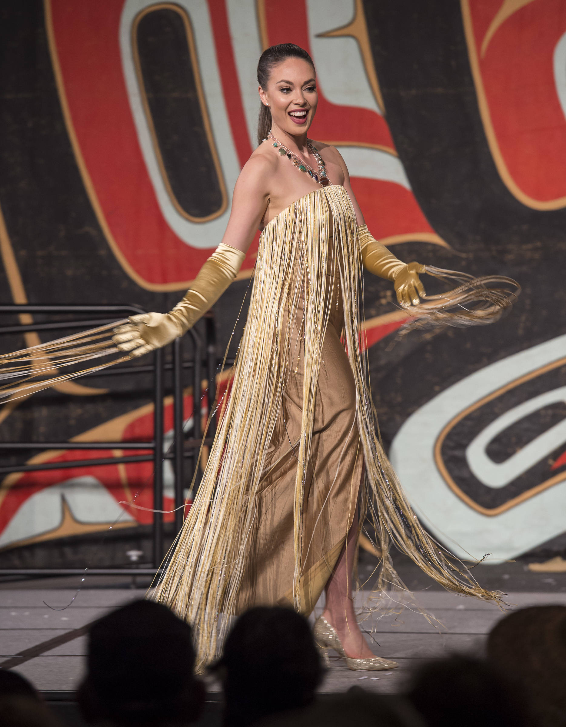 Former Miss Alaska USA Alyssa London displays designers Jason Brown and Donna Decontie-Brown’s work at the Native Fashion Show at Centennial Hall on Friday, June 8, 2018. (Michael Penn | Juneau Empire)