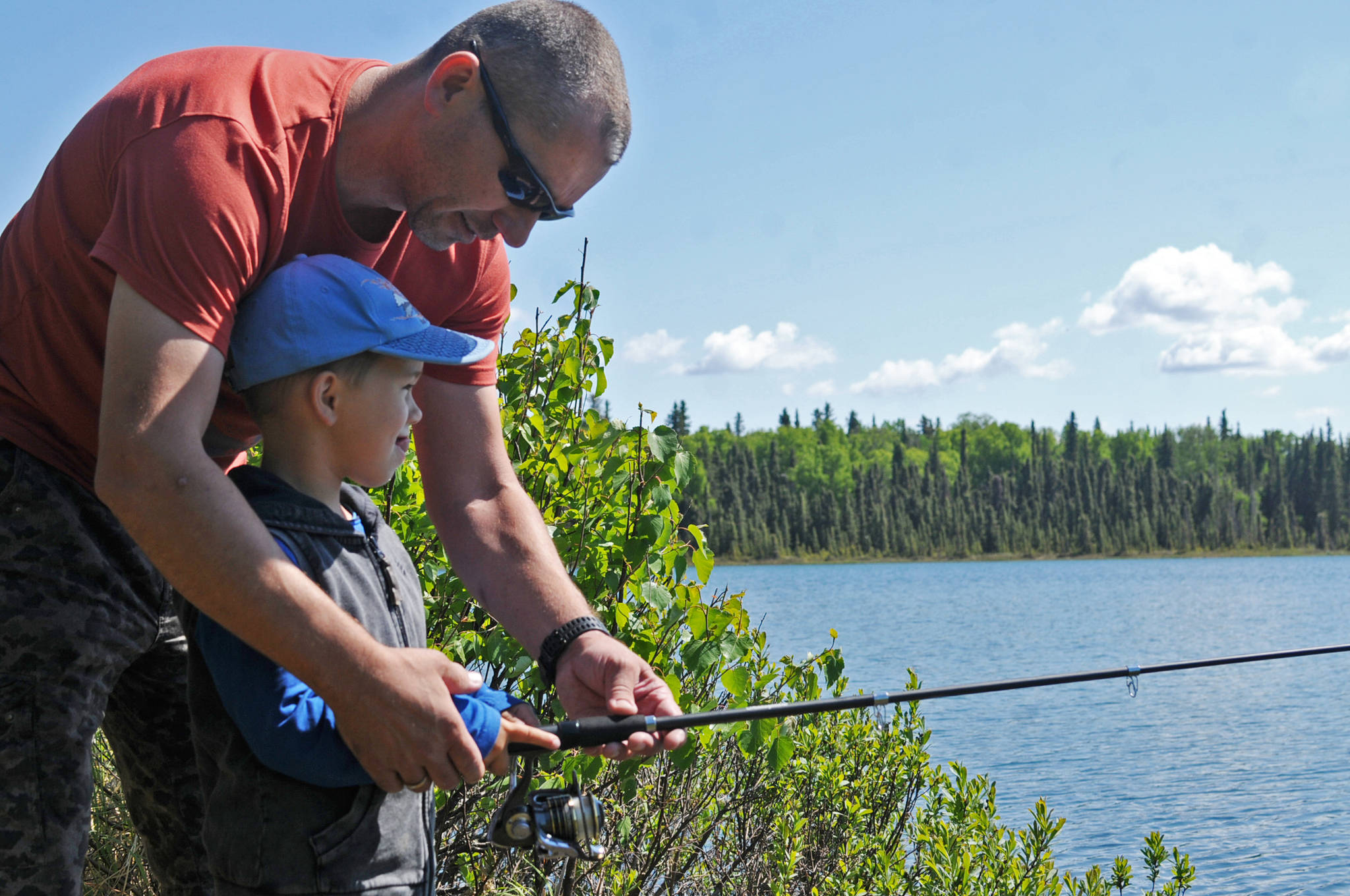Thomas and his son Emil, visiting from Austria, try casting a line into Arc Lake on Wednesday, June 13, 2018 in Soldotna, Alaska. King salmon fishing is restricted on all the streams on the western Kenai Peninsula due to weak returns, but lake fishing and early-run sockeye fishing at the confluence of the Russian and Kenai Rivers is still available to anglers hungry to fish. (Photo by Elizabeth Earl/Peninsula Clarion)