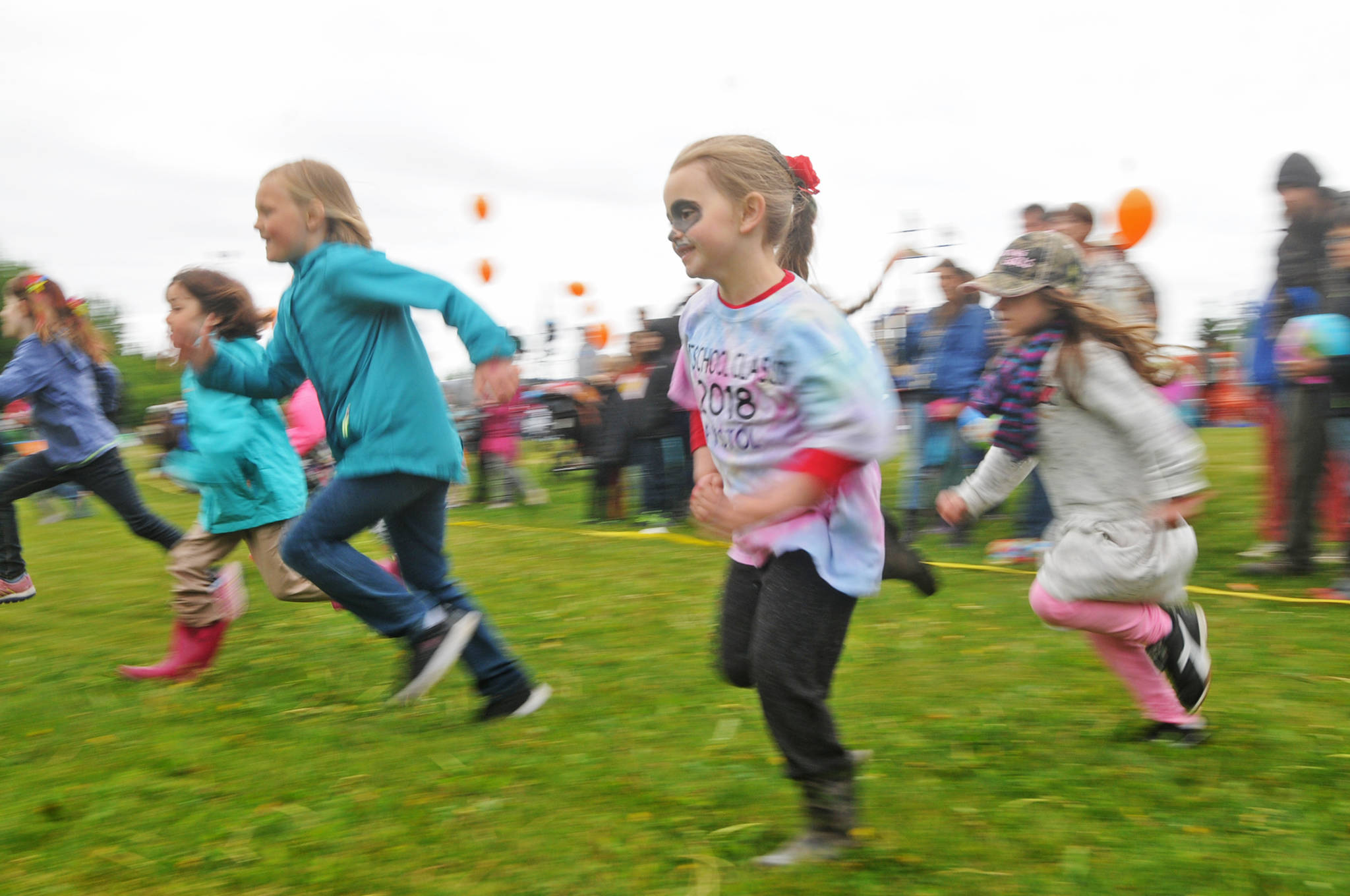 Brystol Flynn, 5, makes a dash for the finish line during a kids’ footrace at the North Peninsula Recreation Service Area’s Family Fun in the Midnight Sun event Saturday, June 16, 2018 in Nikiski, Alaska. The annual event features a variety of booths and activities, including a candy hunt and footraces, martial arts demonstrations, food trucks, raffles and a chance to spray a fire hose courtesy of the Nikiski Fire Department. Though the morning started out chilly and rainy, the rain stopped by early afternoon for awhile. (Photo by Elizabeth Earl/Peninsula Clarion)