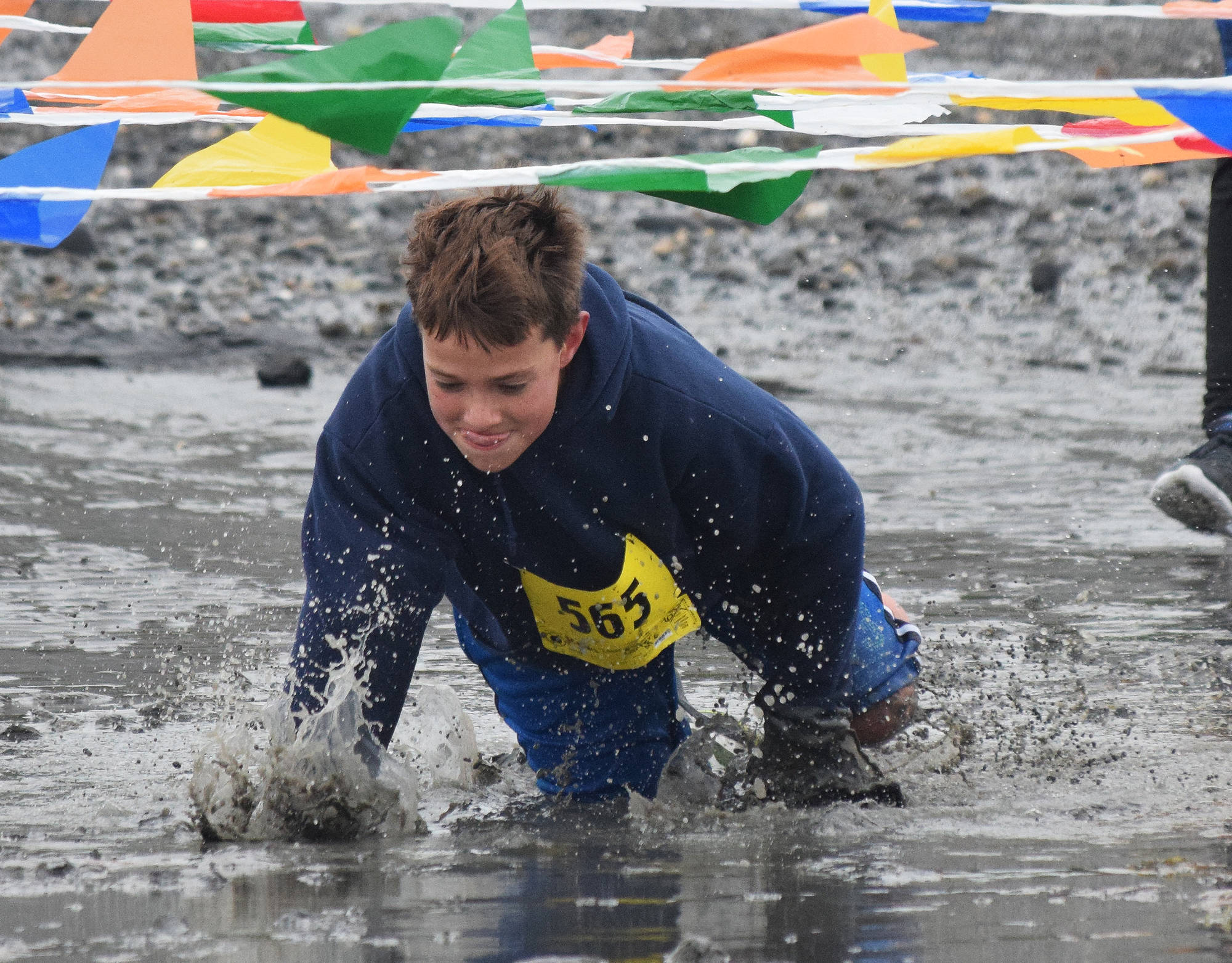 Carter Lemons splashes his way through the mud crawl Saturday at the fourth annual Clam Scramble 5K in Ninilchik. (Photo by Joey Klecka/Peninsula Clarion)