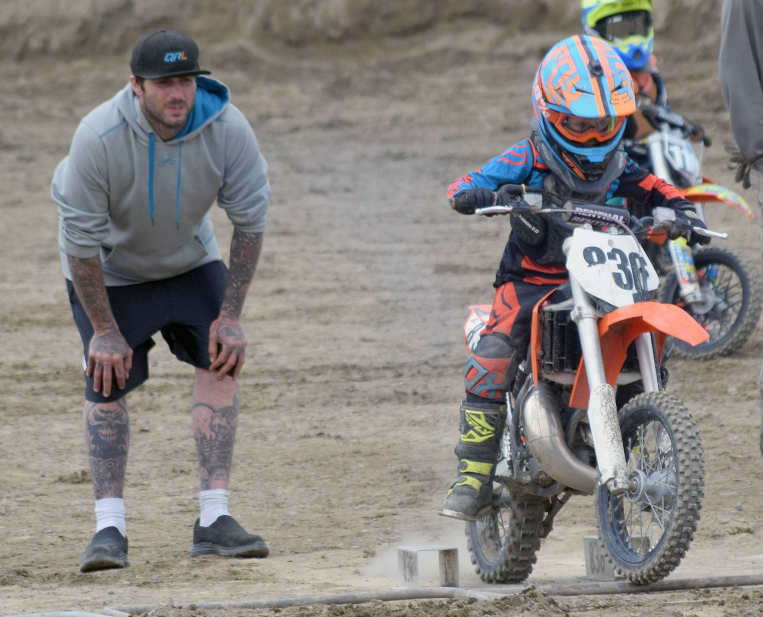 Shane Mullican, of Soldotna, watches as his son, Draiden roars off the starting line in the 65cc Novice race Sunday, June 17, 2018, at the Alaska State Motocross Championships at Twin City Raceway. (Photo by Jeff Helminiak/Peninsula Clarion)