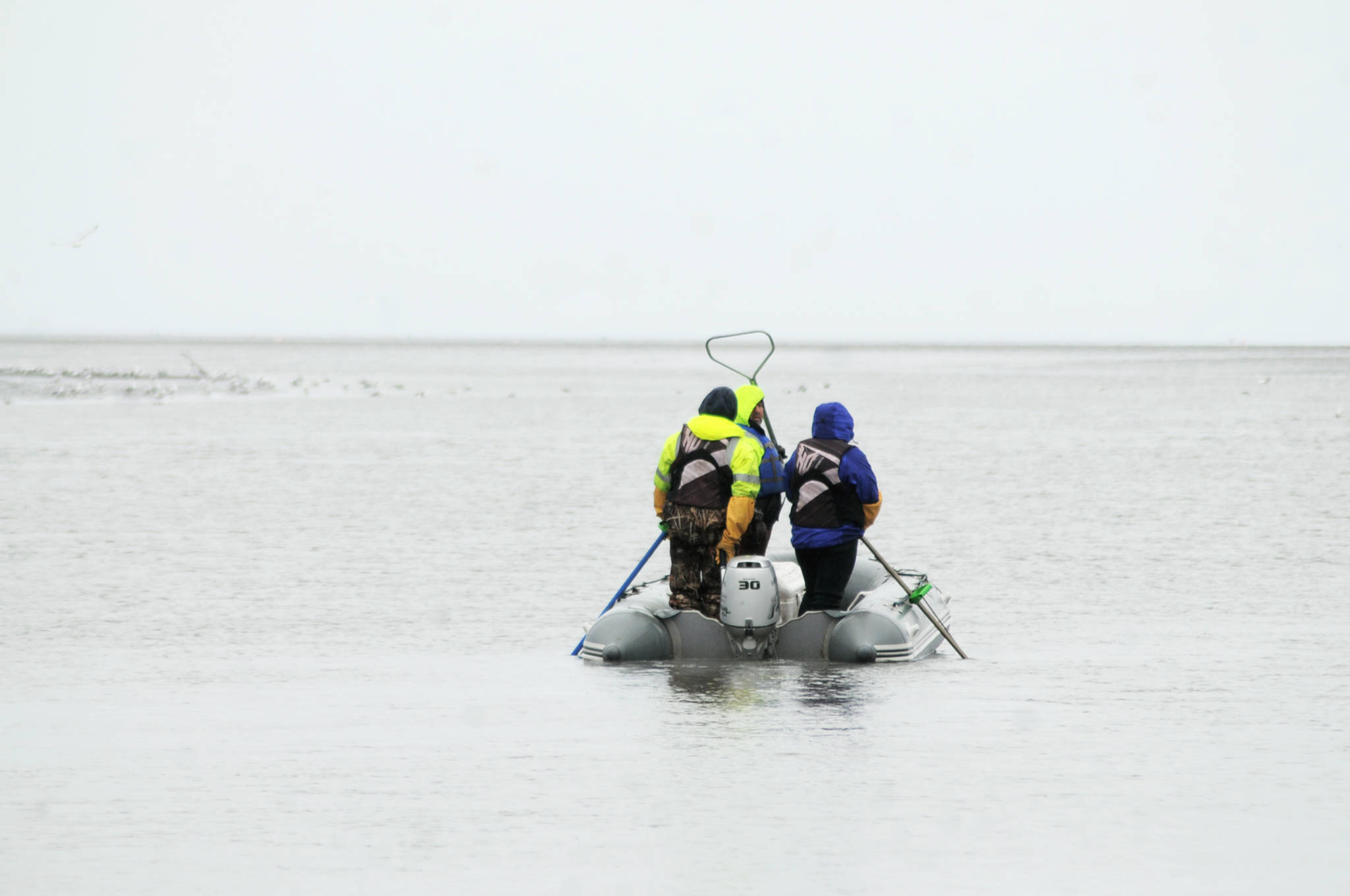 A group of anglers dipnet for sockeye salmon near the mouth of the Kasilof River on Wednesday, June 28, 2018 in Kasilof, Alaska. The personal-use dipnet fishery on the Kasilof River opened Monday, with fish counts significantly behind last year and behind the 10-year average for the same date. Some fishermen were successful Wednesday, though, both from shore and from boats. (Photo by Elizabeth Earl/Peninsula Clarion)