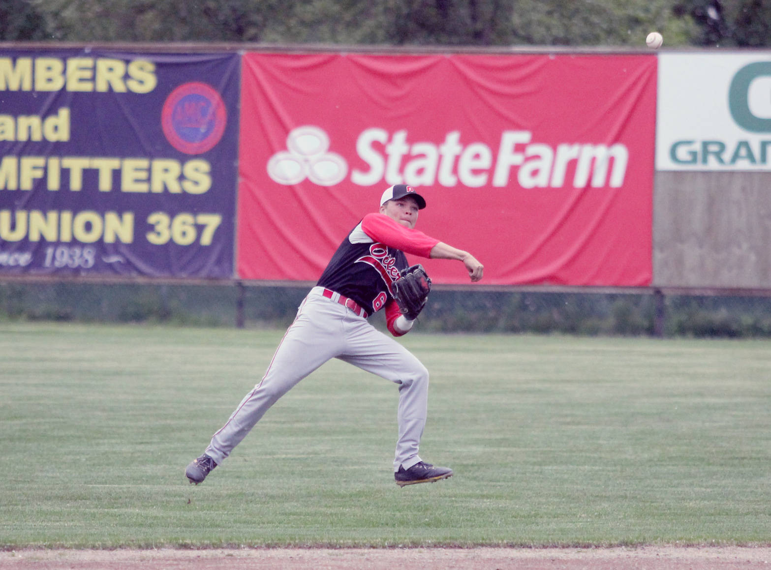 Peninsula Oilers shortstop Evan Berkey tries to make the throw to first Thursday, June 28, 2018, while spinning in the air after fielding a ball deep in the infield during an 8-7 loss to Mat-Su. (Photo by Jeremiah Bartz/Frontiersman)