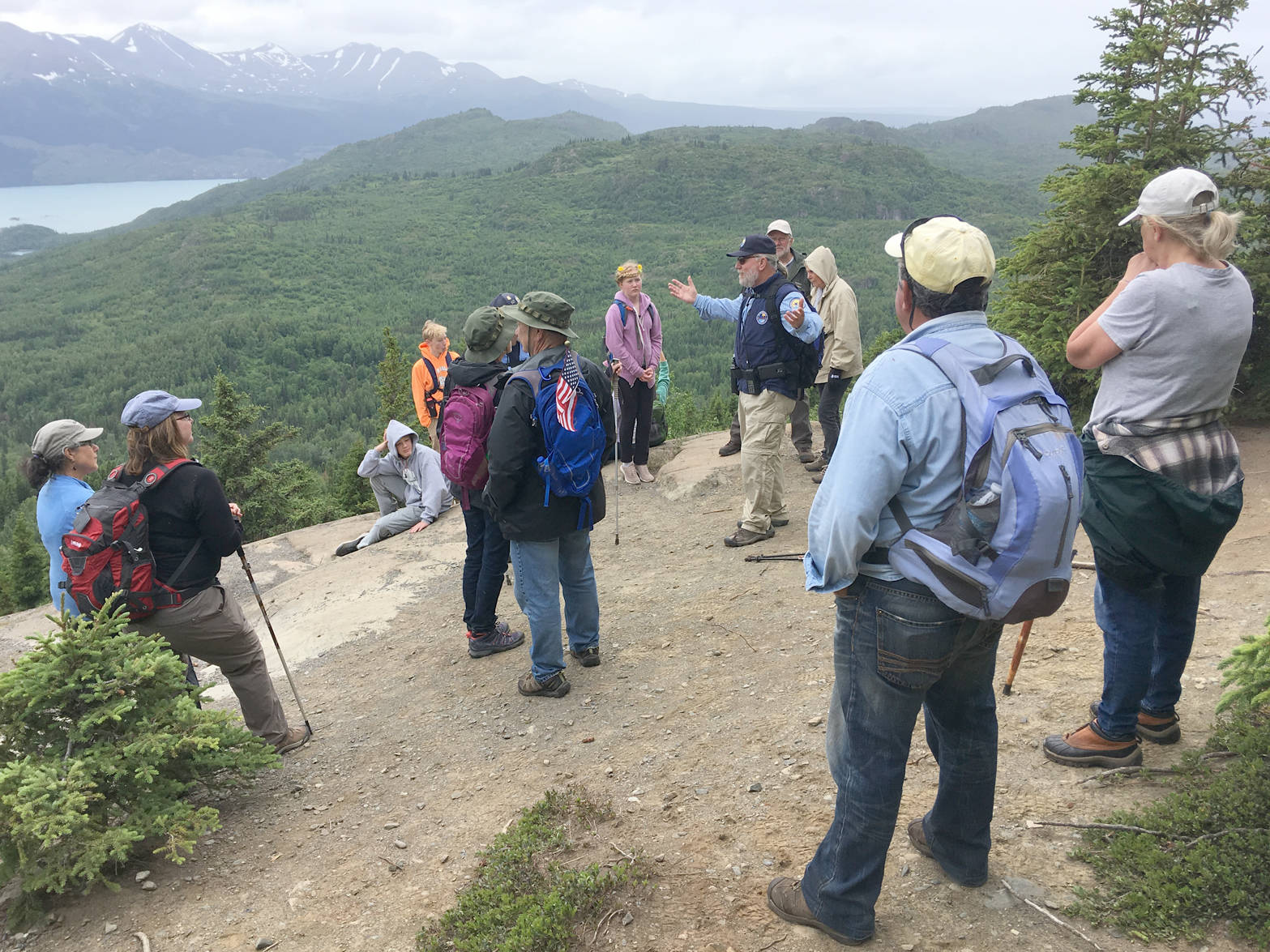 Bill Farrell, a volunteer host at the Kenai National Wildlife Refuge Visitors Center, tells a group about the refuge’s history during Take a Hike at the top of the Bear Mountain trail Friday, June 29, 2018. (Photo by Jeff Helminiak/Peninsula Clarion)