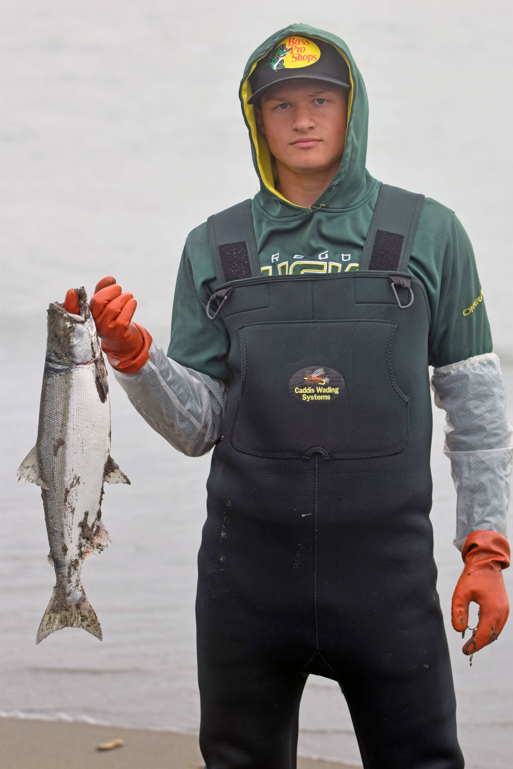 Anchorage resident Colton Herman displays a recently caught salmon on Kenai Beach during the opening day of dipnetting season on Tuesday, July 10, 2018, in Kenai, Alaska. Herman has come to Kenai to participate in dipnetting every year since he was a child. Herman said the catch had been slow so far, but would continue fishing until he got his quota. (Photo by Erin Thompson/Peninsula Clarion)