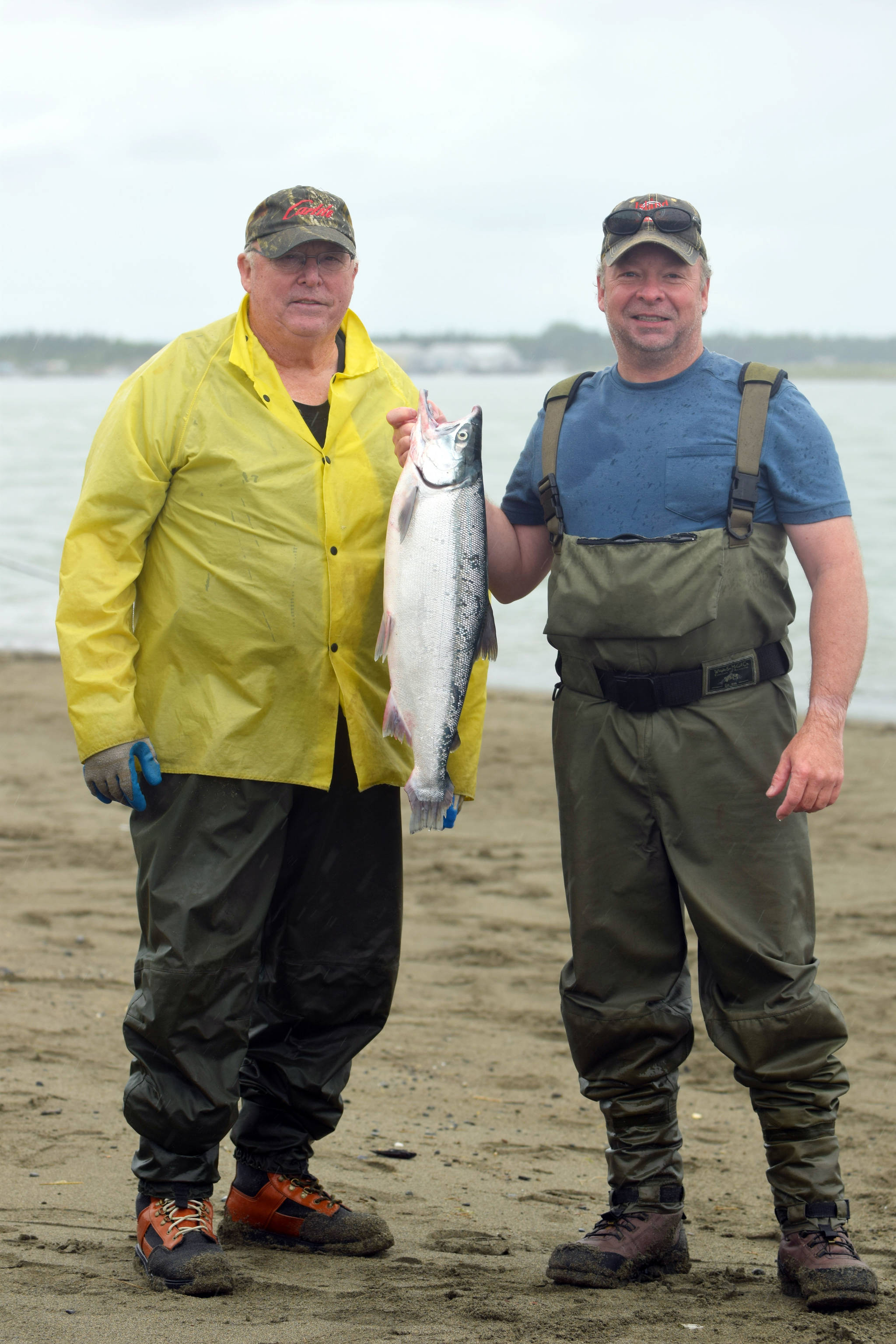Fred, right, and Bob Kring show off their catch on Kenai Beach on Tuesday, July 10, 2018, in Kenai, Alaska. The two, who regularly travel to Kenai to participate in the dipnetting season, said the fishing had been “terrible” so far this year. Even so, they had snagged two salmon and a flounder by mid-afternoon Tuesday. (Photo by Erin Thompson/Peninsula Clarion)
