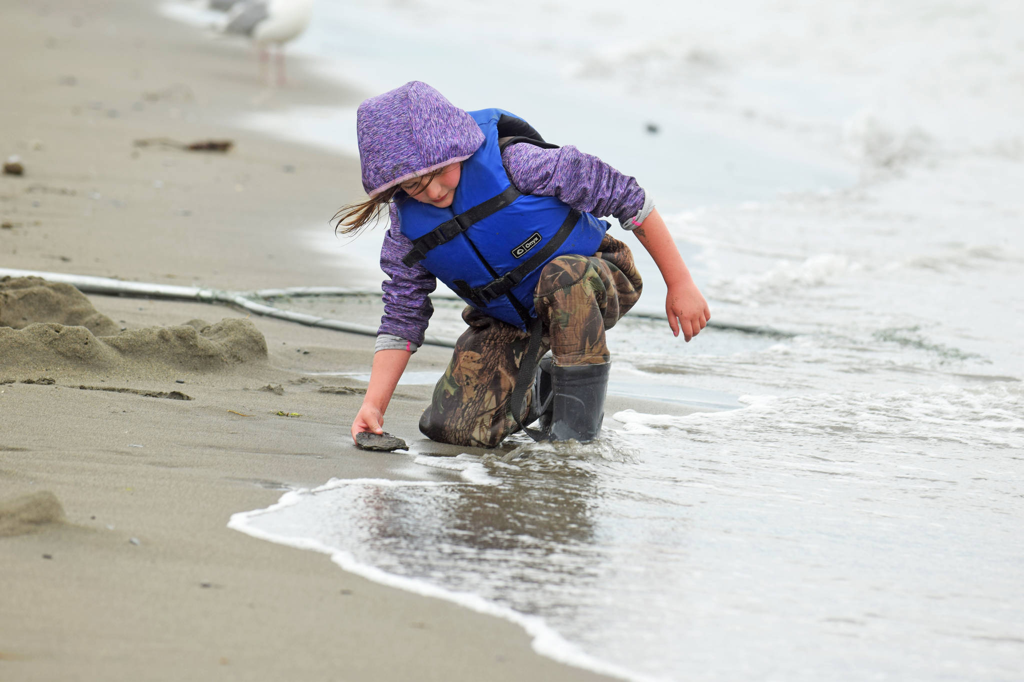 A young dipnetter plays in the sand on Kenai Beach on Tuesday, July 10, 2018, in Kenai, Alaska. (Photo by Erin Thompson/Peninsula Clarion)