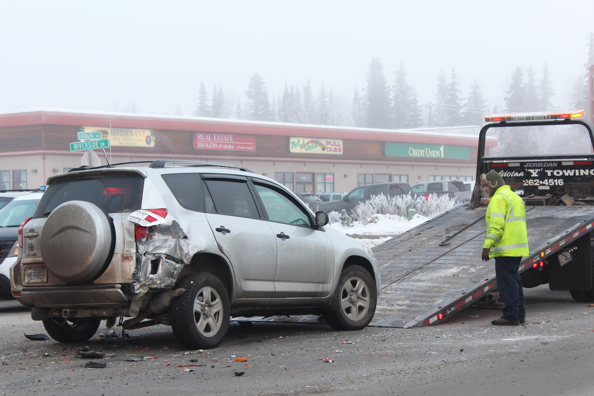 Members of Soldotna Y Towing Inc. prepare a vehicle to be taken away from the scene of a four-vehicle accident on Wednesday, Jan. 11, 2017 on the David Douthit Veterans Memorial Bridge in Soldotna, Alaska. One person was taken to the hospital with non-life threatening injuries. (Megan Pacer/Peninsula Clarion)