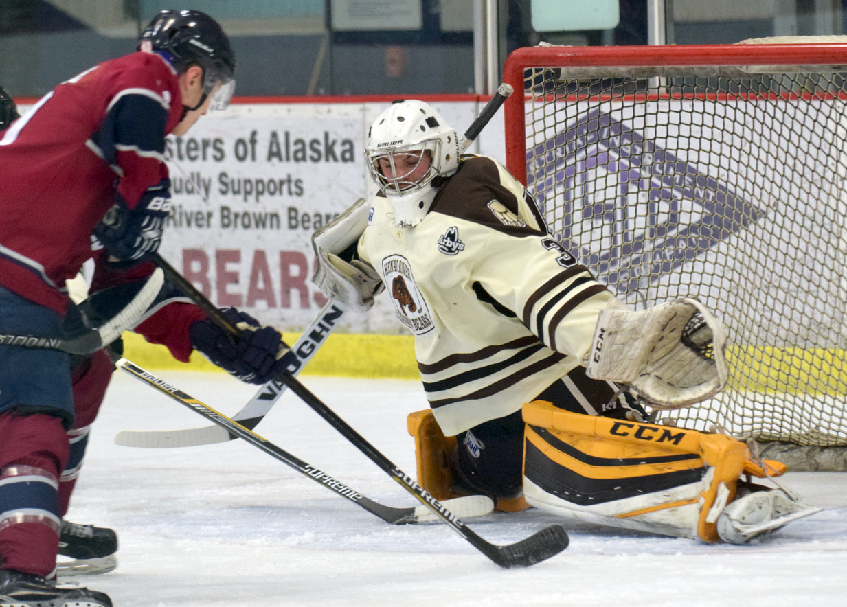 Kenai River Brown Bears goalie Robbie Goor makes a save on Tanner Schachle of the Ice Dogs on Nov. 27, 2016, at the Soldotna Regional Sports Complex. (Photo by Jeff Helminiak/Peninsula Clarion)