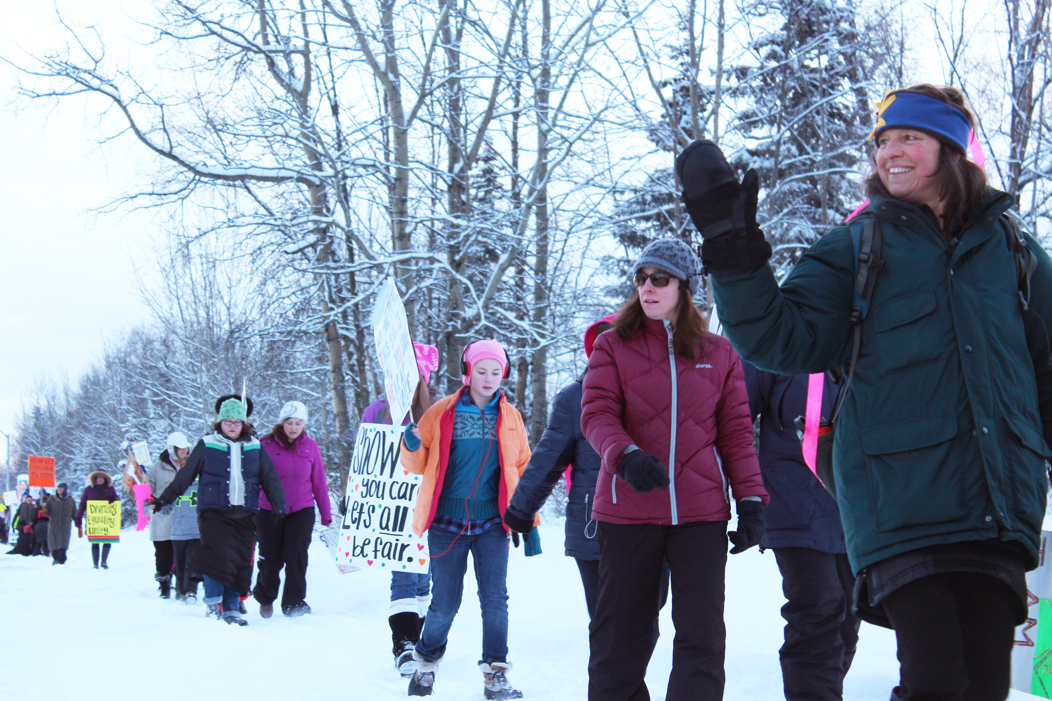 Area residents wave at cars passing by while they march down Binkley Street during a Women's March held Saturday, Jan. 21, 2017 in Soldotna, Alaska. Marchers held signs advocating for a number of issues, from women's reproductive rights to clean water. (Megan Pacer/Peninsula Clarion)