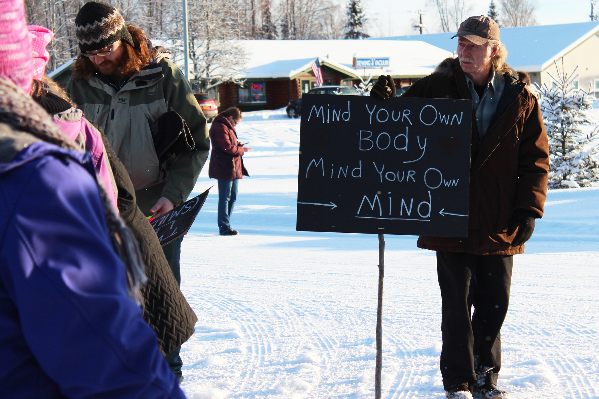 Carroll Knutson of Soldotna queues up behind a crowd of people just before taking off in a Women's March held Saturday, Jan. 21, 2017 in Soldotna, Alaska. Organizers said the march was a demonstration meant to bring area residents together to voice what they would like to see in their communities, whether it related to women's right or myriad other issues. (Megan Pacer/Peninsula Clarion)
