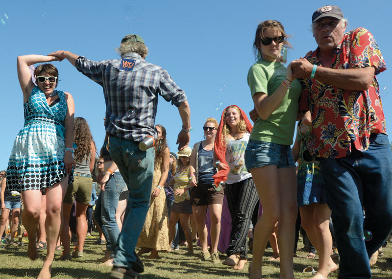 Revelers at Salmonstock dance in the grass during a concert at the Ninilchik Fairgrounds.