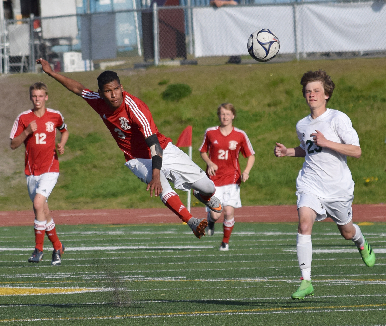 Kenai Central midfielder Kevin Ramos (center) sends the ball downfield in Friday's state soccer semifinal against Service at Service High School.