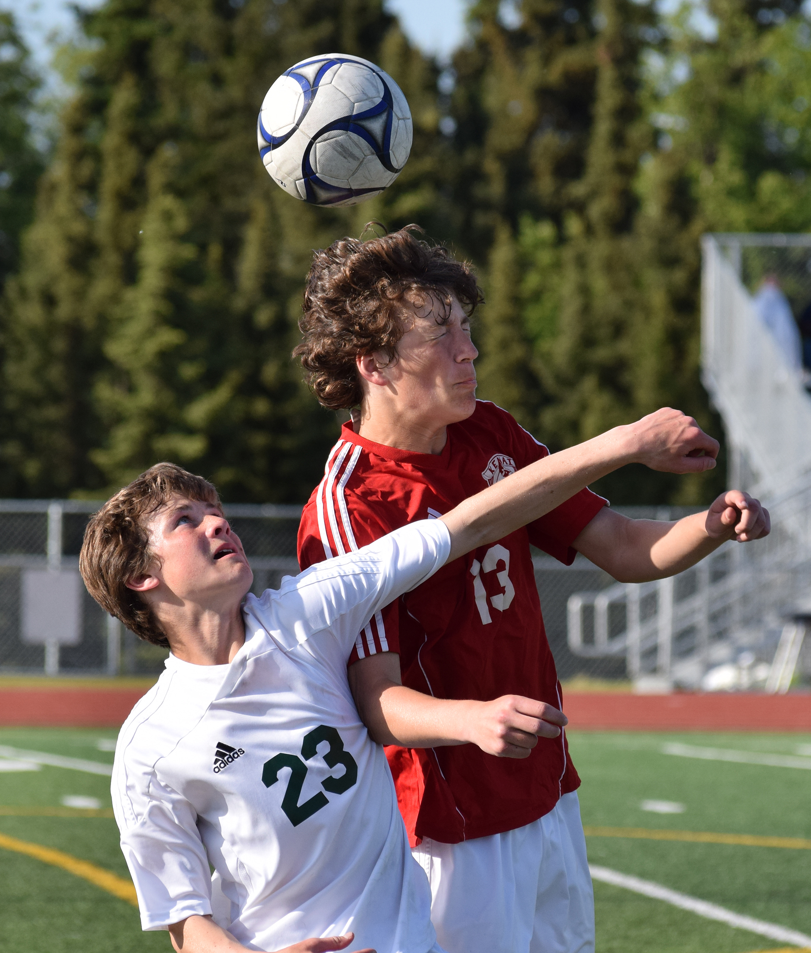 Kenai Central freshman Damien Redder (13) heads the ball with Service sophomore Dorian Cornichuck in Friday's state soccer semifinal contest at Service High School.