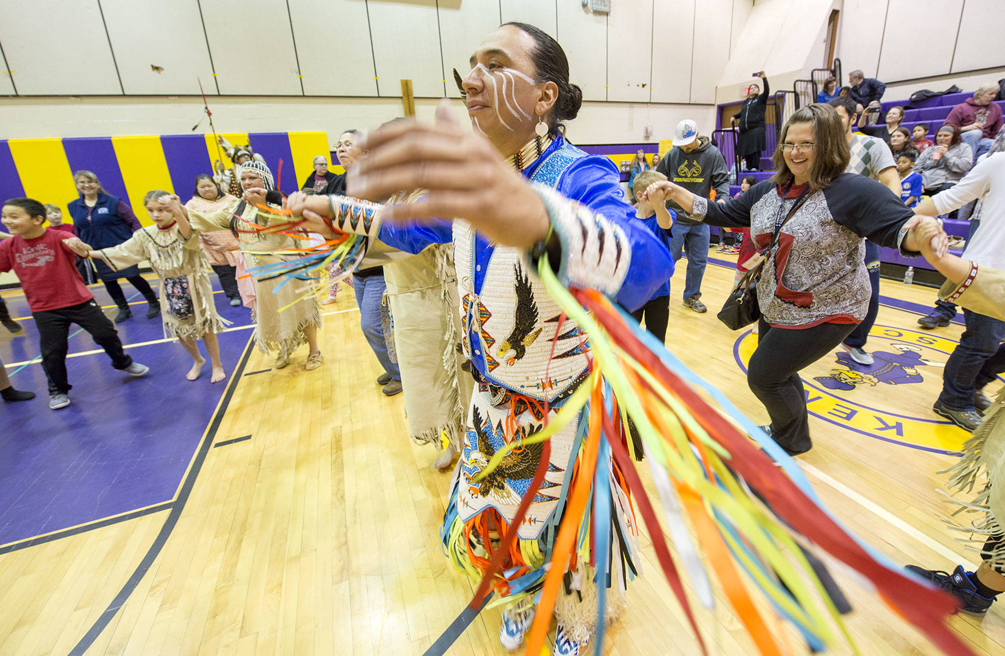 Larry Yazzie, of the Minnesota-based Native Pride Dancers, helps lead Native Youth Olympics participants and members of the crowd in a Circle Dance during the Native Youth Olympics Invitational at Kenai Middle School in January. (M. Scott Moon/Kenaitze Indian Tribe)