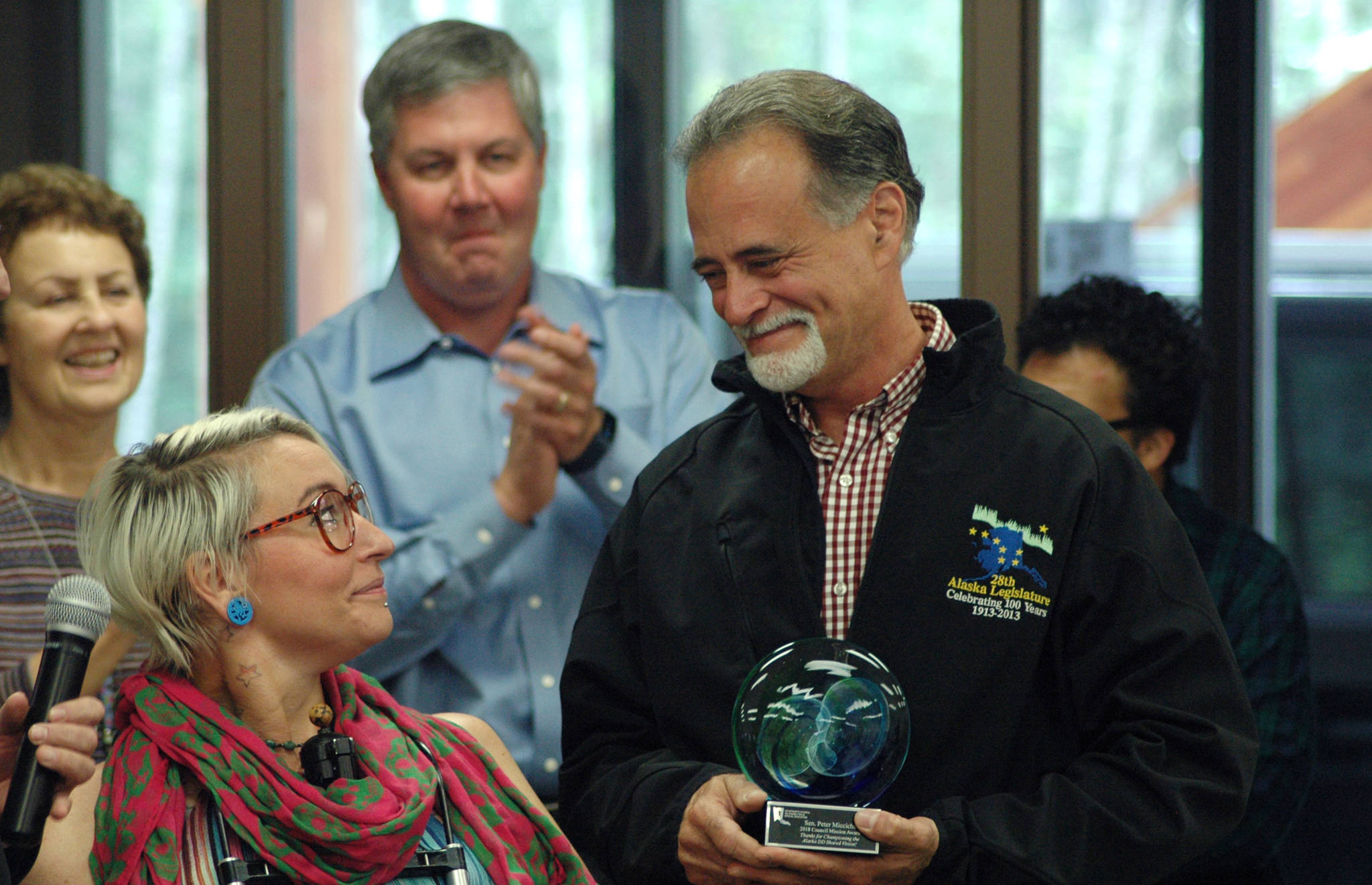 Sen. Peter Micciche, R-Soldotna (right) thanks Maggie Winston, the chair of the Governor’s Council on Disabilities and Special Education, for an award the board presented to him for his work on Senate Bill 174 during a signing ceremony for the bill at Hope Community Resources’ building on Saturday, Aug. 25, 2018 in Soldotna, Alaska. (Photo by Elizabeth Earl/Peninsula Clarion)