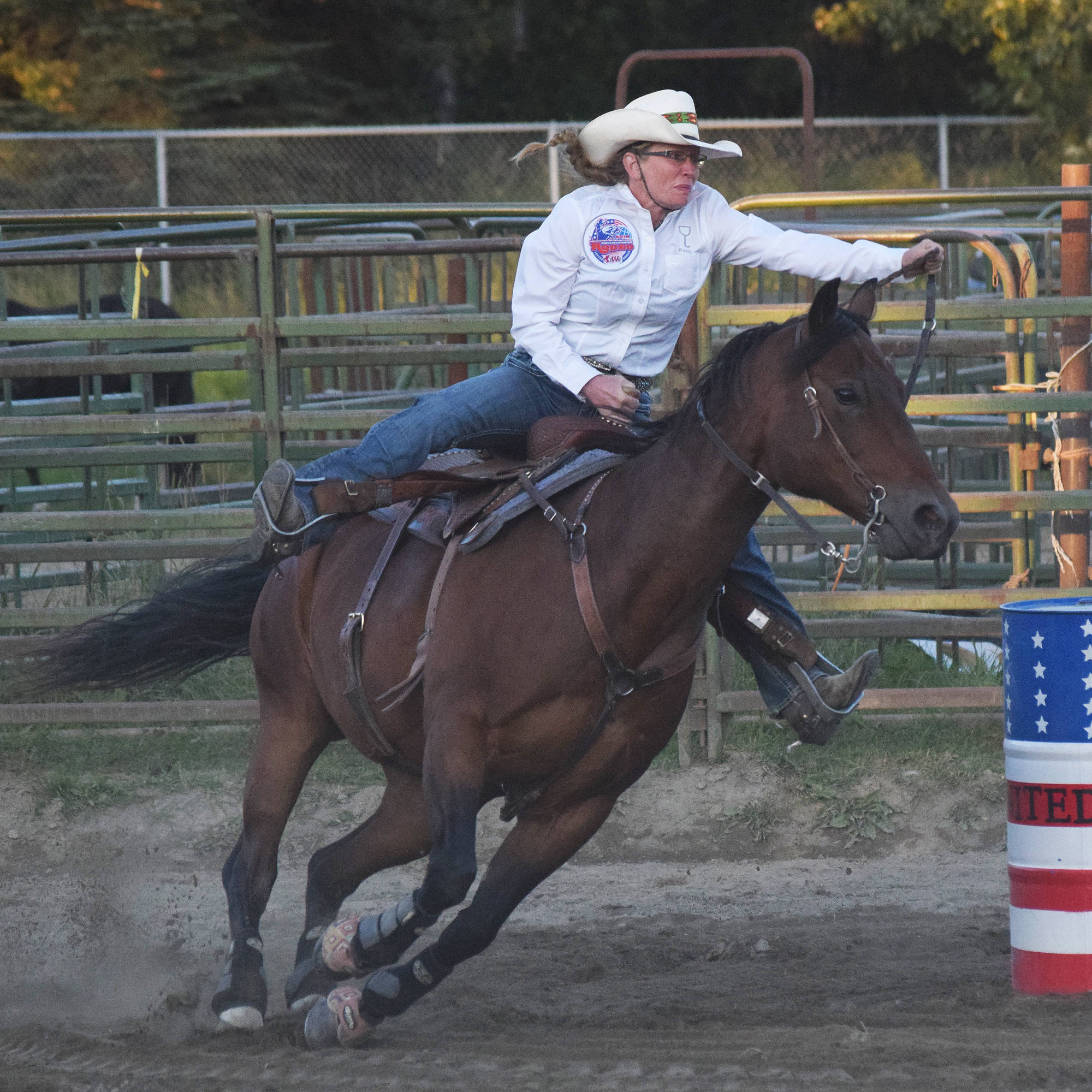 Karen Jensen spurs her horse on during the barrel racing event Saturday at the 9/11 Tribute Rodeo at the Soldotna Rodeo Grounds. (Photo by Joey Klecka/Peninsula Clarion)