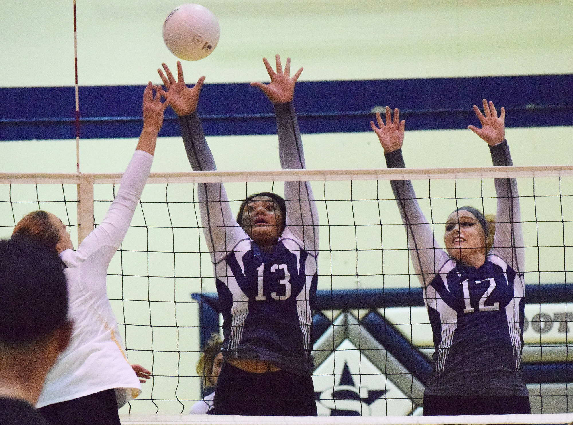 Soldotna juniors Ituau Tuisaula (13) and Bailey Leach team up to block a ball by Nikiskis Bethany Carstens, Tuesday at Soldotna High School. (Photo by Joey Klecka/Peninsula Clarion)