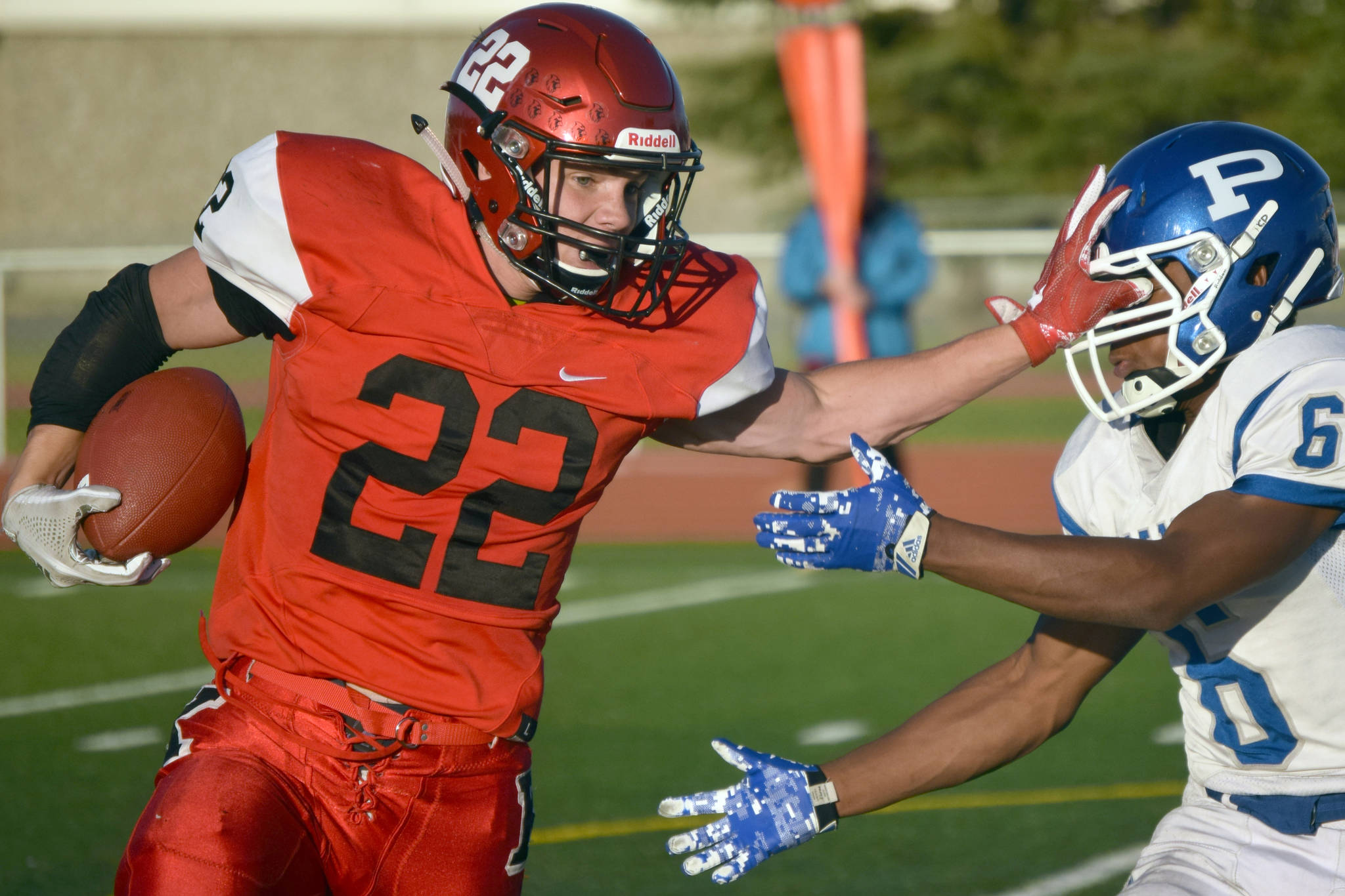 Kenai Central’s Titus Riddall wards off Palmer’s Morgan Freeman on Friday, Aug. 24, 2018, at Ed Hollier Field in Kenai. (Photo by Jeff Helminiak/Peninsula Clarion)