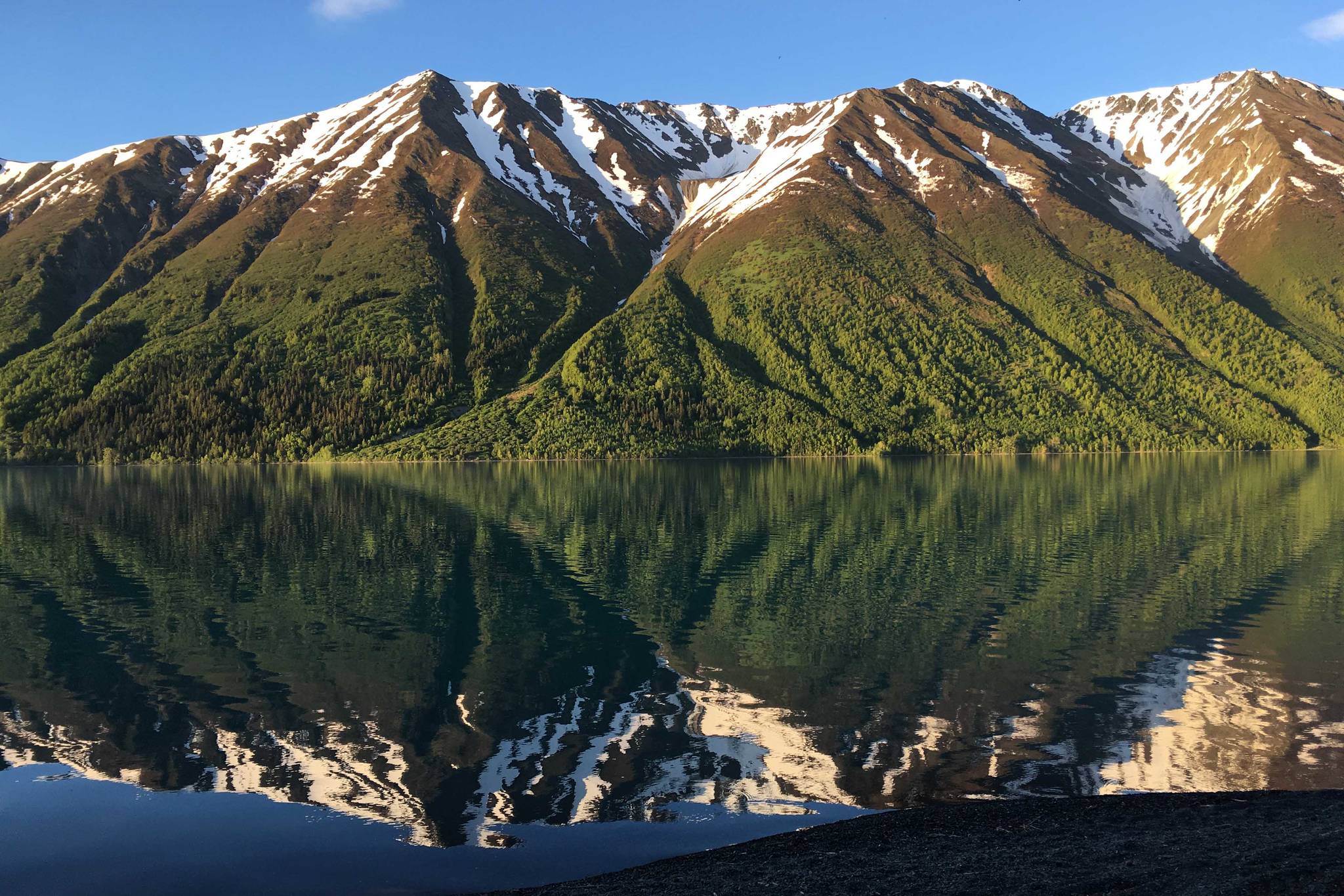 Right Mountain reflects off of Kenai Lake on June 6, 2018. (Photo by Jeff Helminiak/Peninsula Clarion)